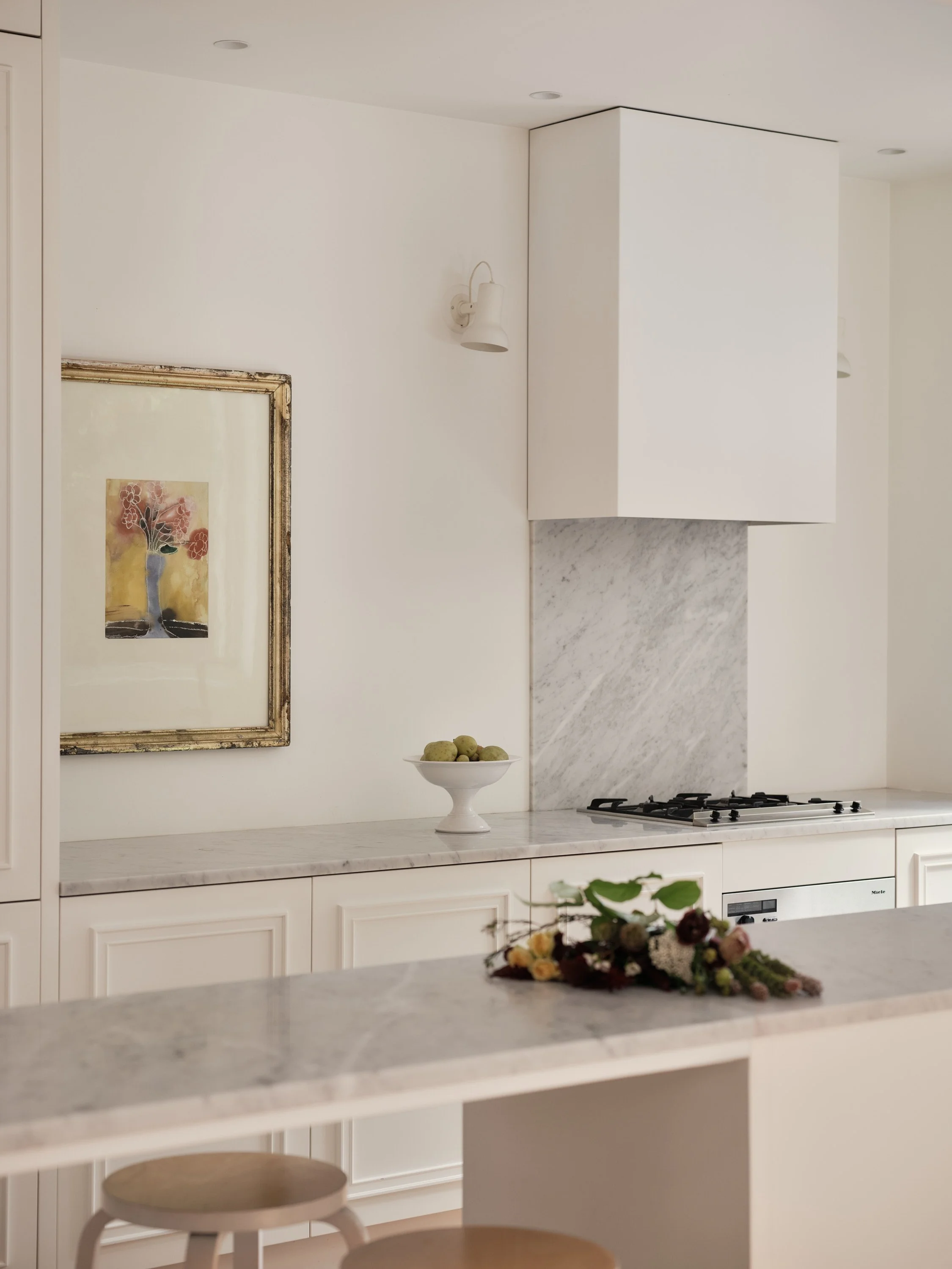 Classic Parisian-style kitchen in white lacquer and molded doors, Carrera marble countertop. Herringbone oak flooring