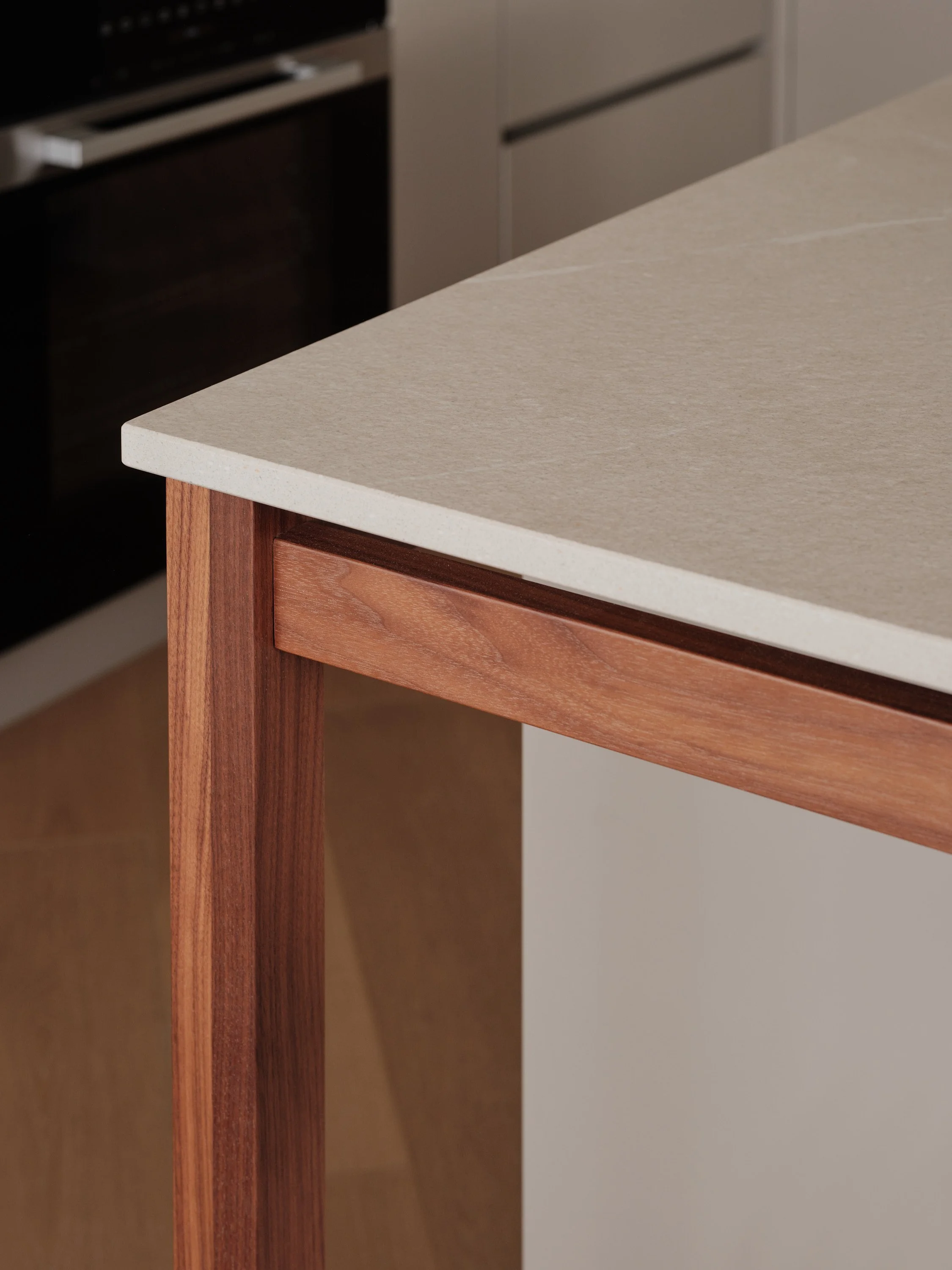 Detail of the custom-made island combining a wooden structure and a stone-effect worktop