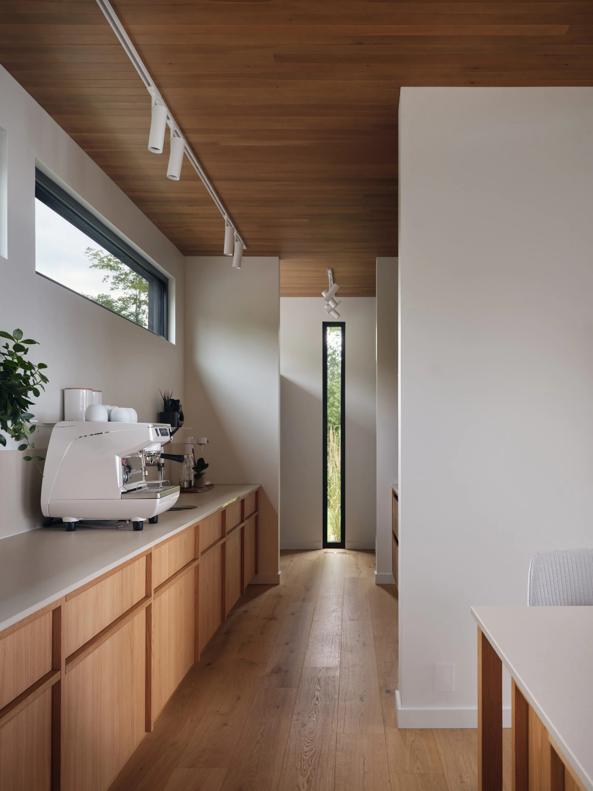 Mobilier intégré sur mesure en bois mettant en valeur la lumière naturelle et les textures des matériaux.