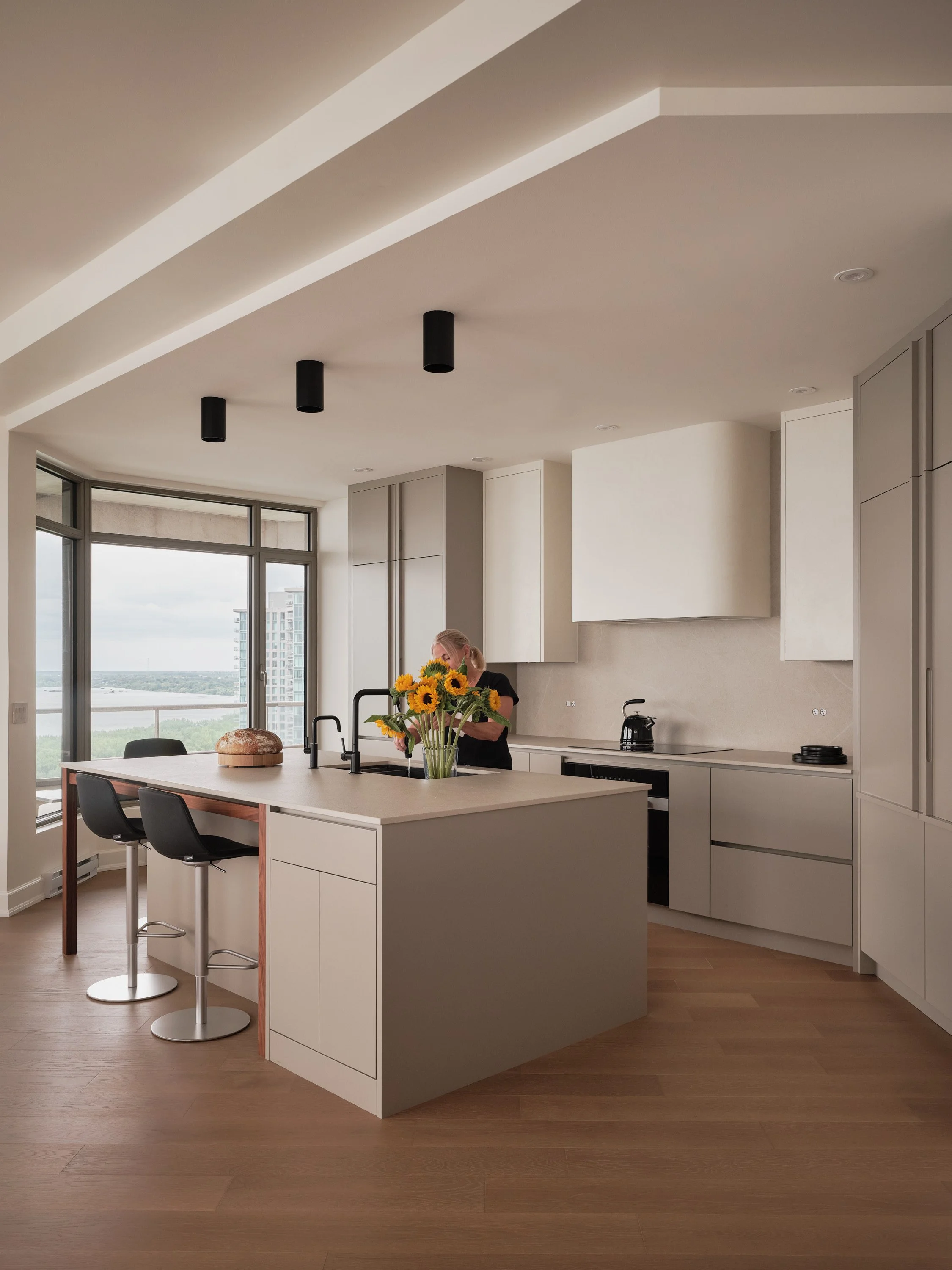 Contemporary kitchen with custom-made island and large windows overlooking the landscape.