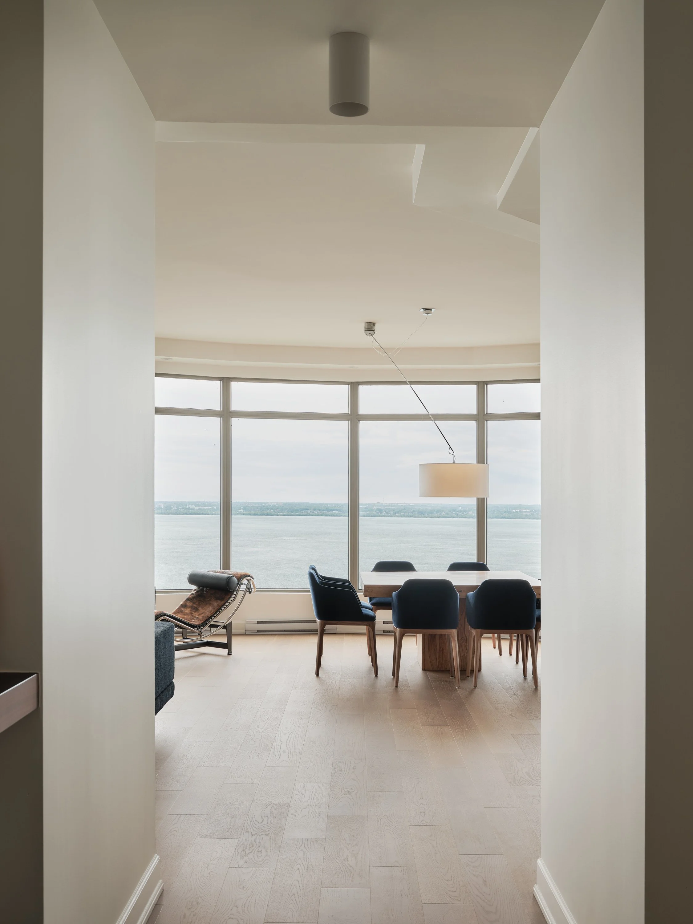 Espace de vie contemporain du Projet De la Pointe avec grandes fenêtres et vue dégagée.