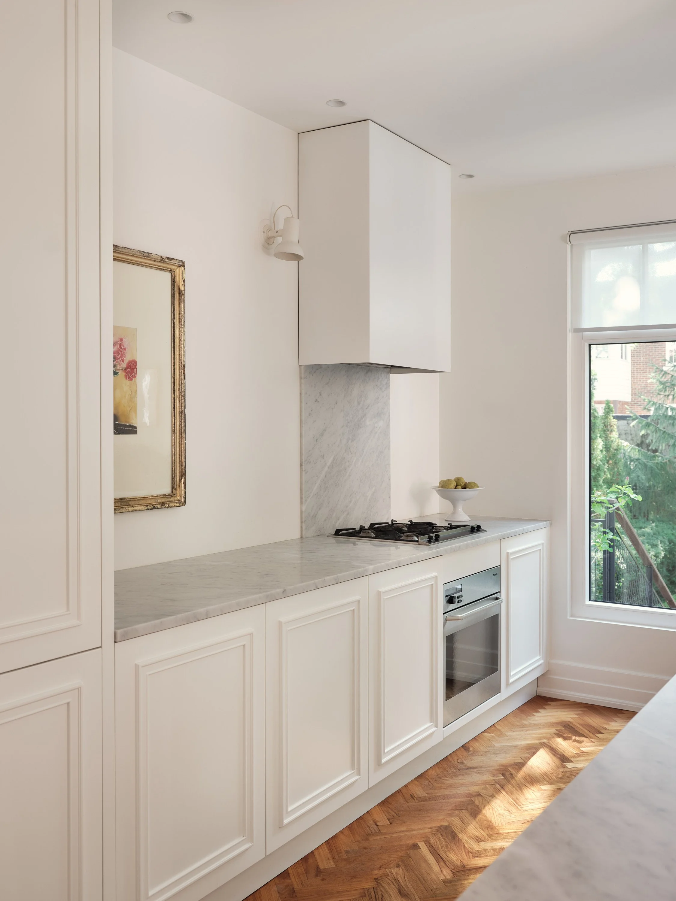 Classic Parisian-style kitchen in white lacquer and molded doors, Carrera marble countertop.