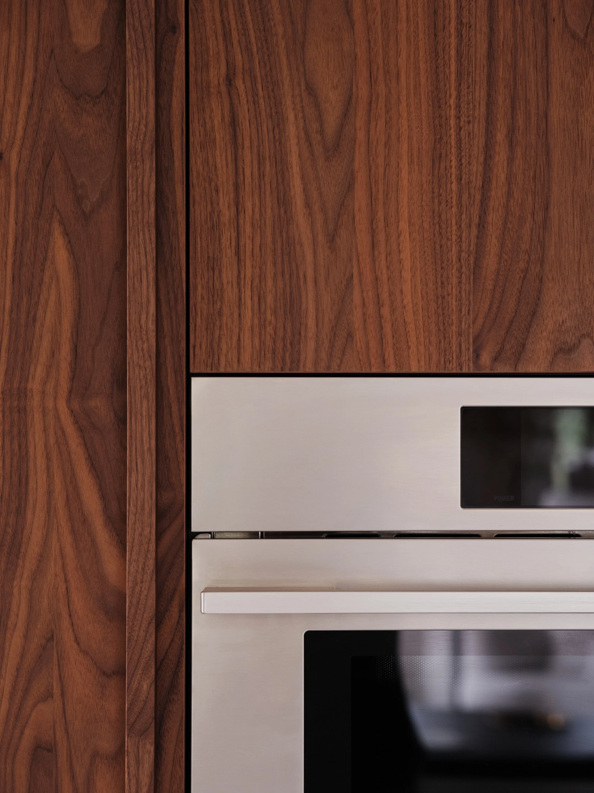 Électroménagers encastrés dans une ébénisterie de cuisine en noyer sur mesure
