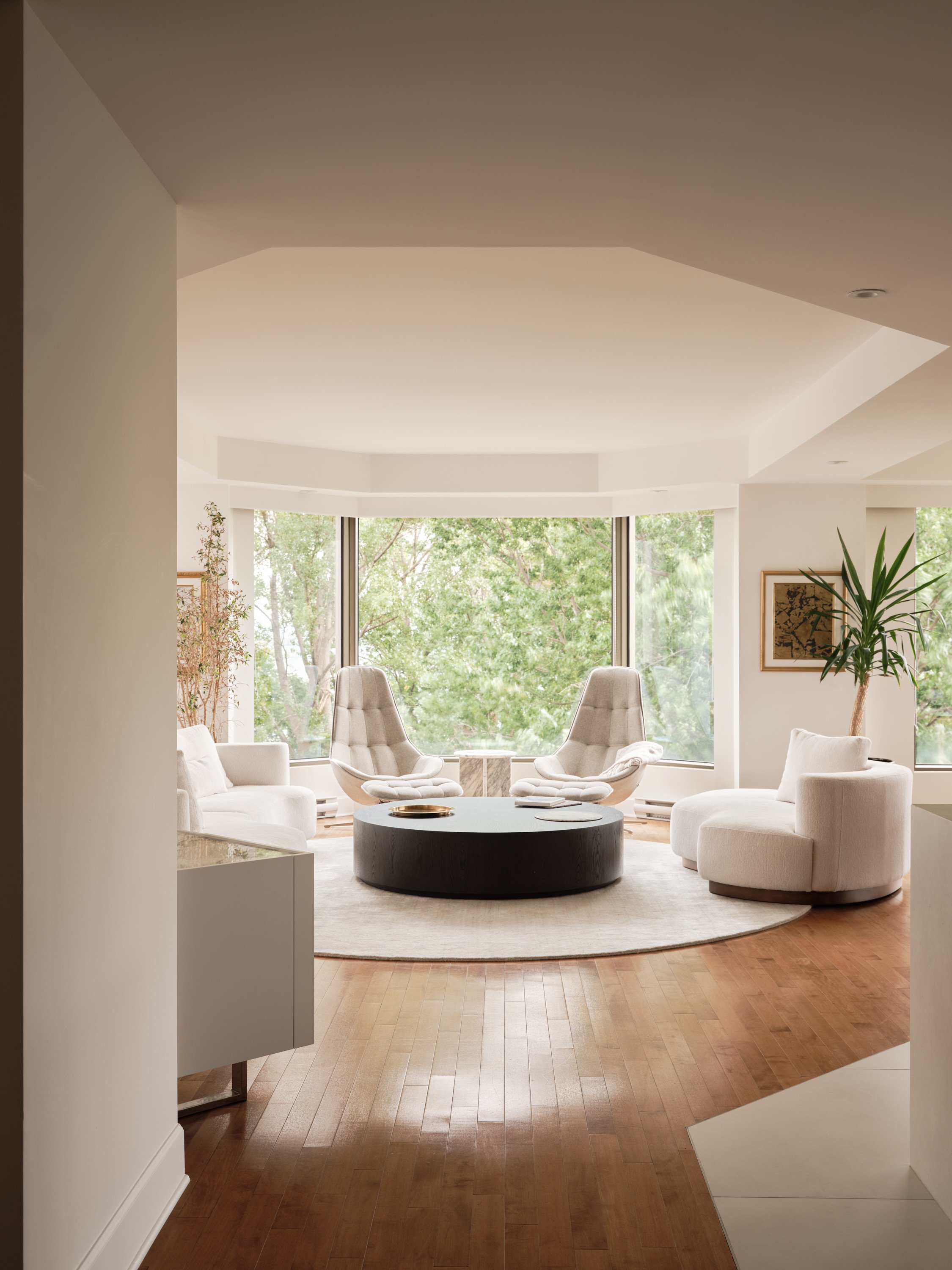 Espace de vie lumineux du Projet des Sommets avec plancher de bois et grandes fenêtres.