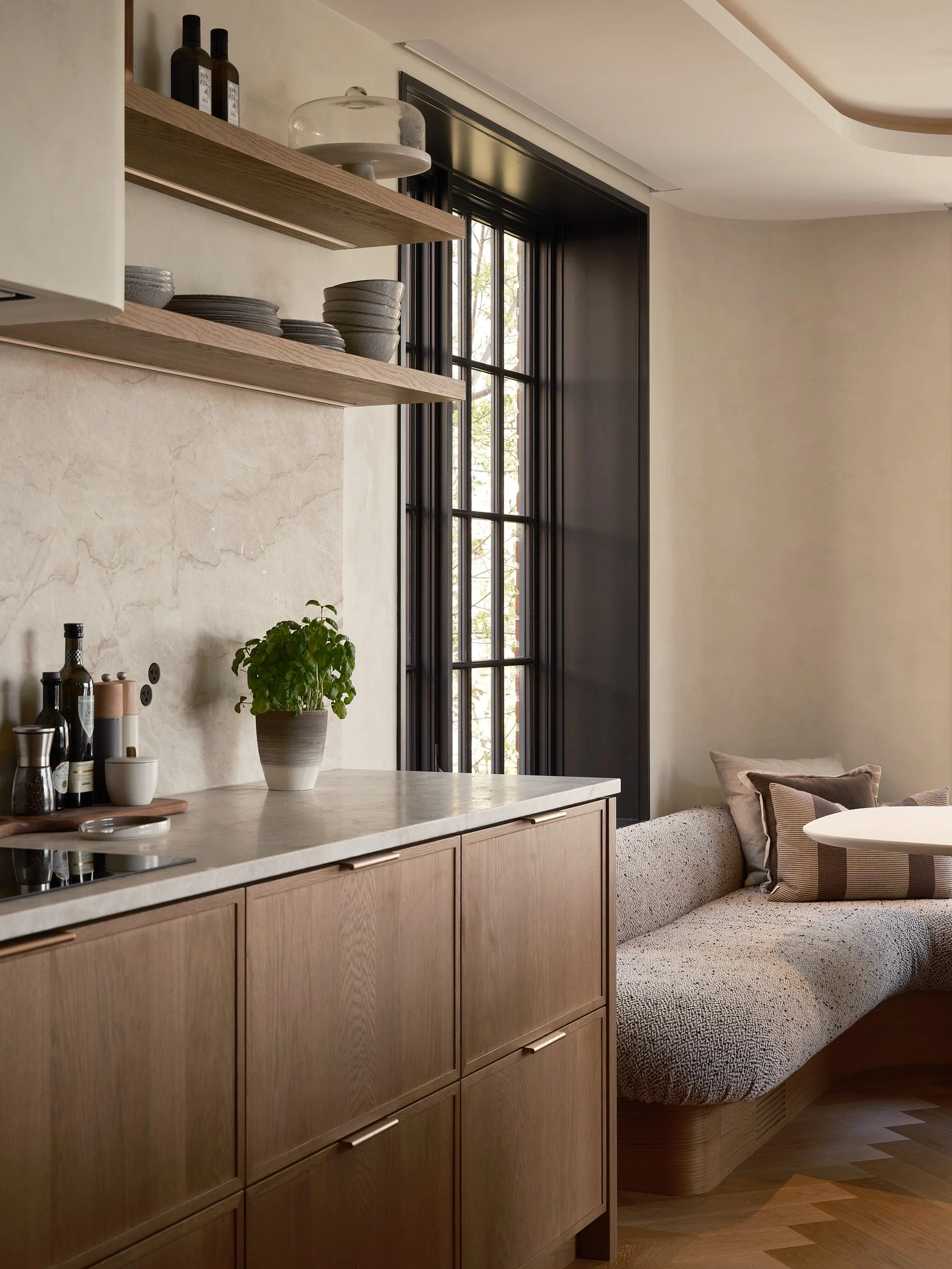 Détail de l’ébénisterie en bois et de la banquette intégrée qui prolonge l’aménagement de la cuisine.