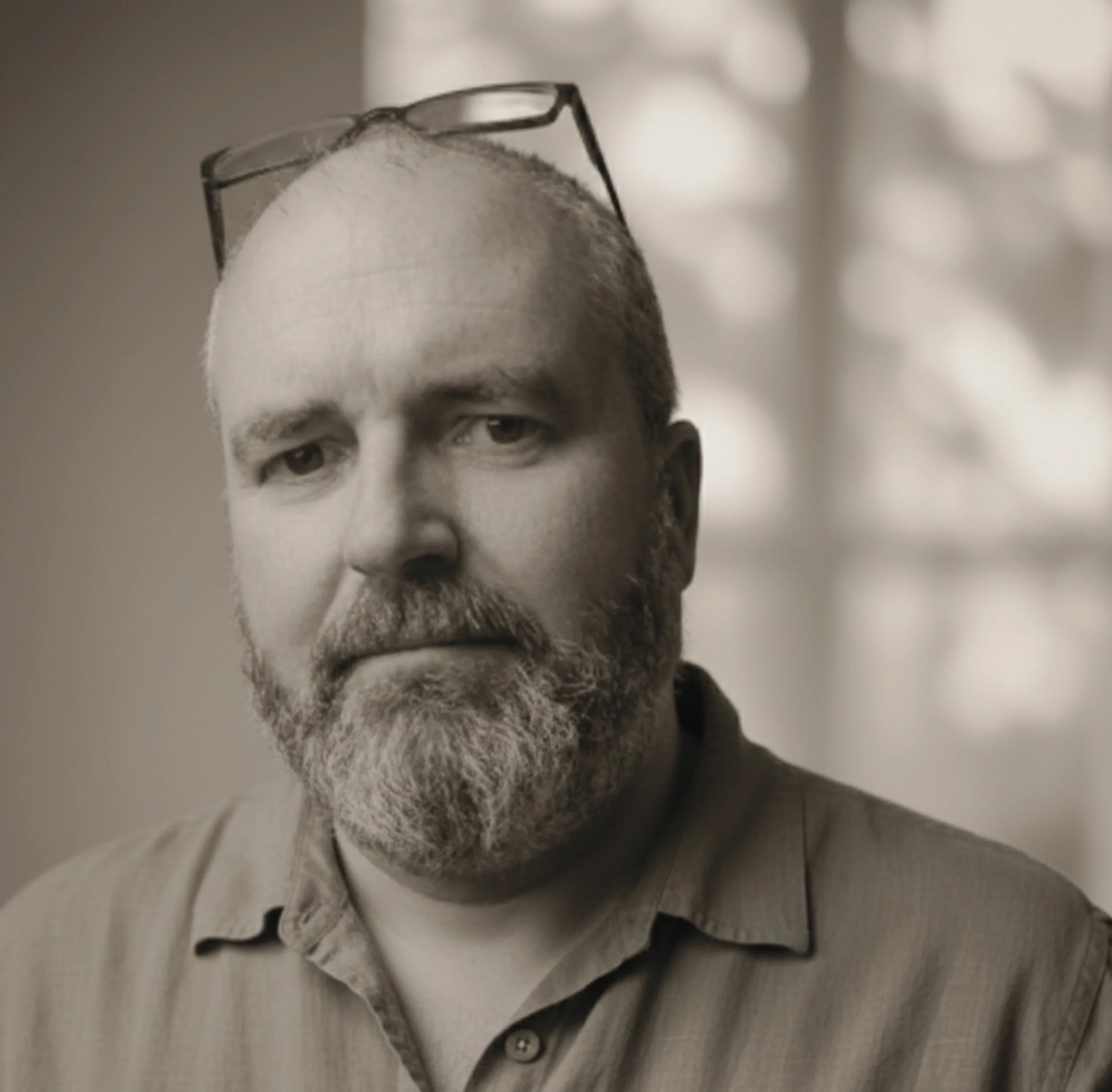 Portrait of composer David Gerard Geraghty wearing glasses and a linen shirt