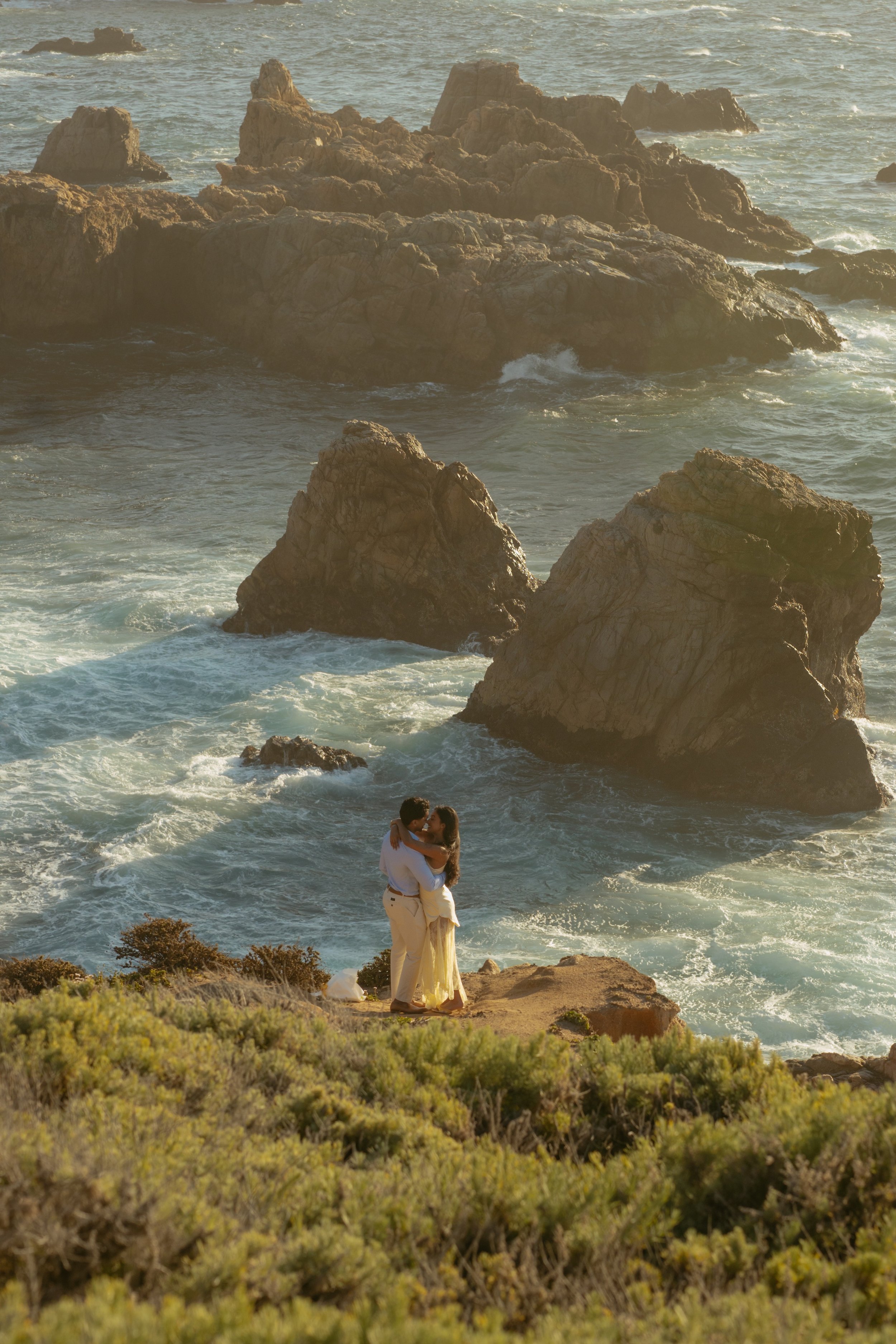 couple embracing after proposal at garrapata state park in carmel california