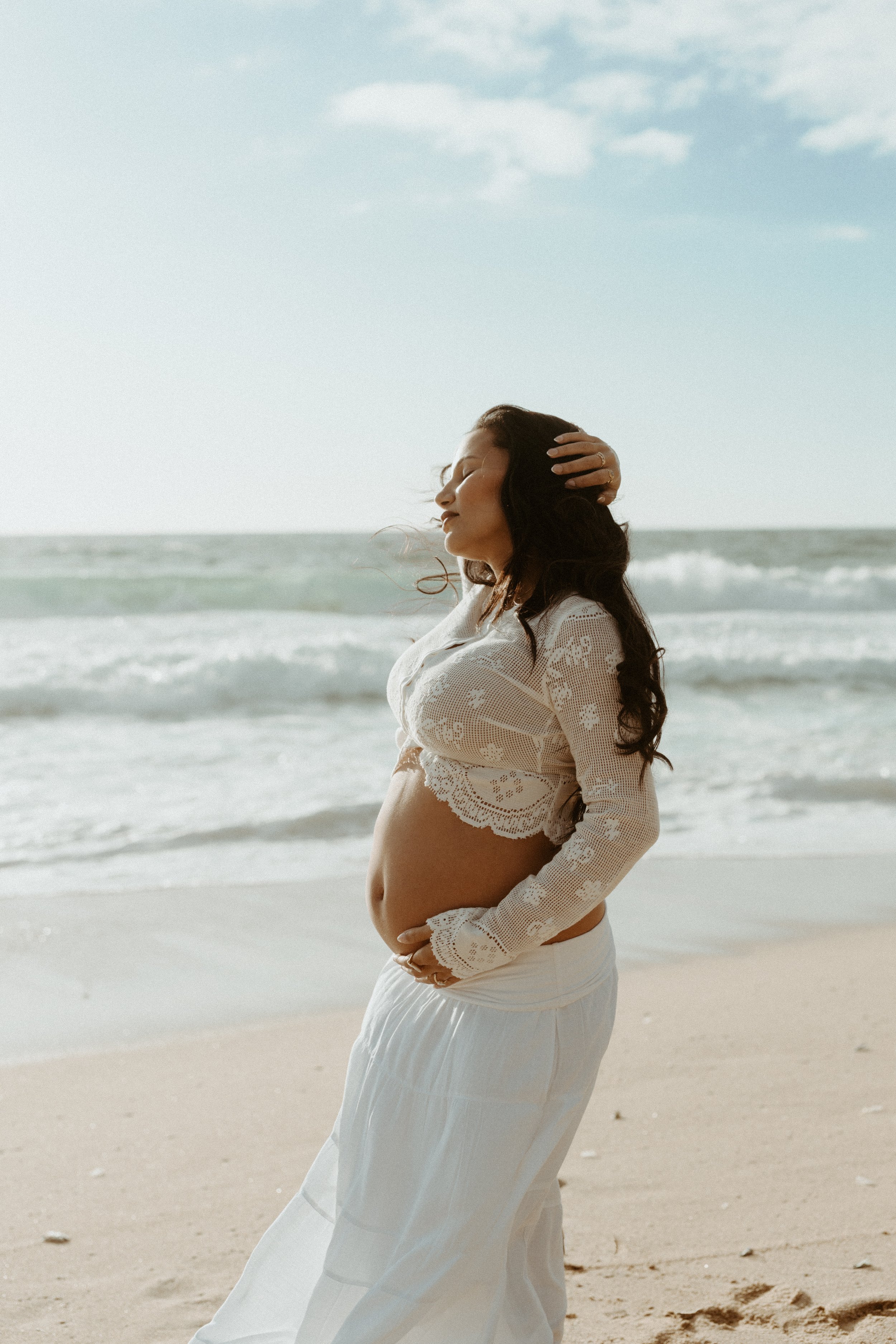 mom to be on beach for maternity babymoon photoshoot posing