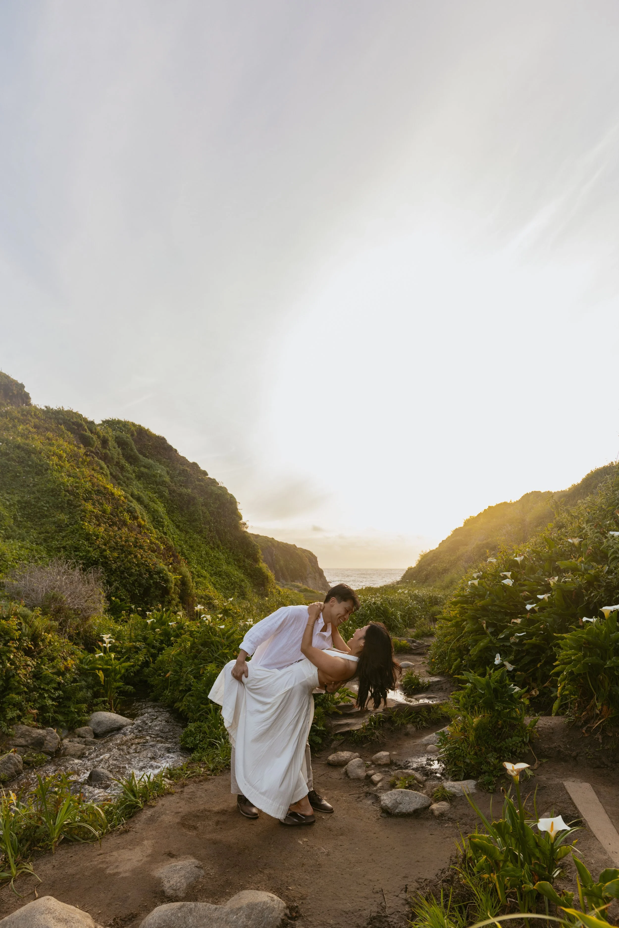 man dipping girlfriend after proposing in carmel by the sea calla lily valley
