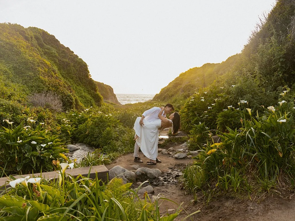 man dipping woman after proposing in Calla Lily Valley