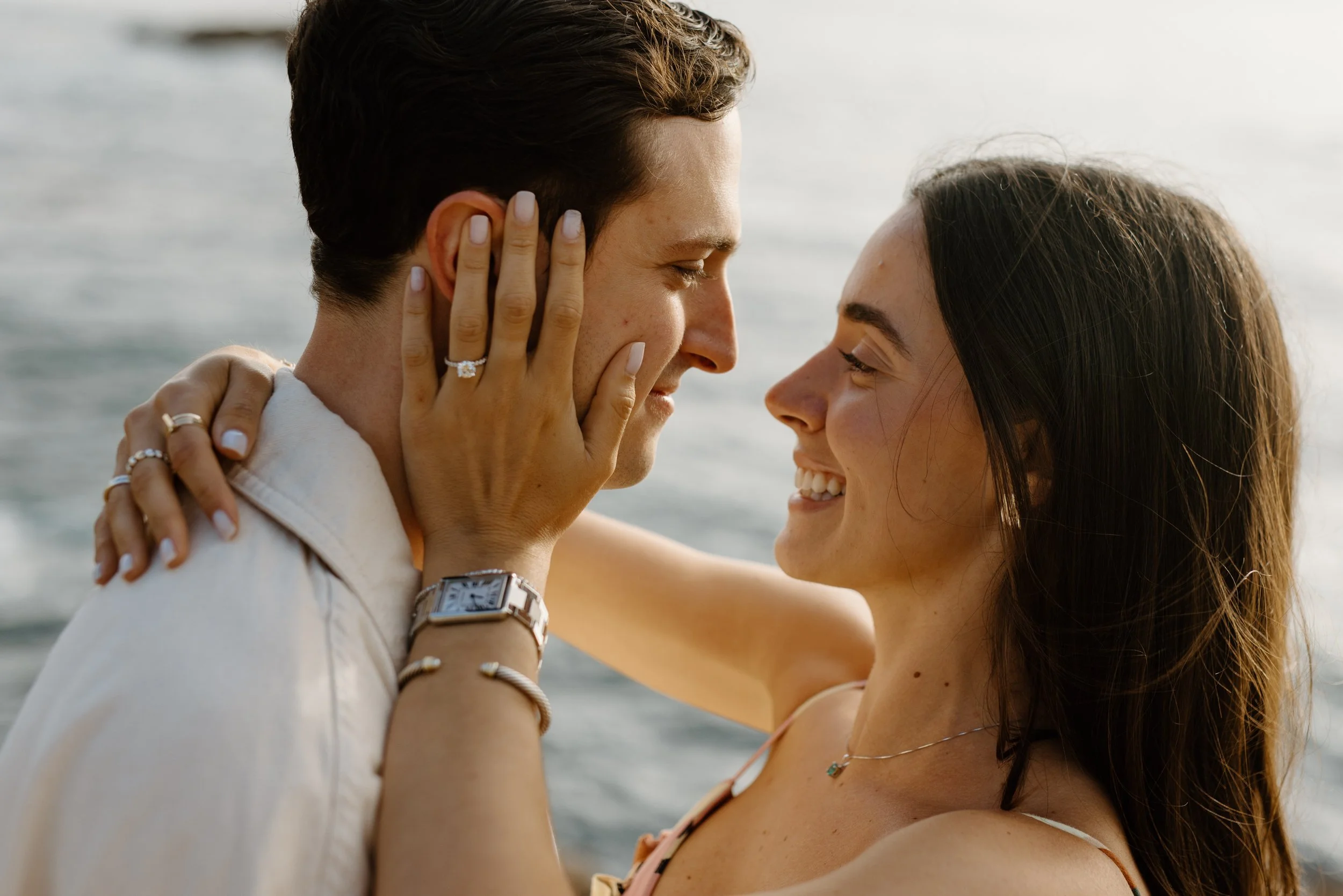 couple smiling at each other during engagement photo shoot