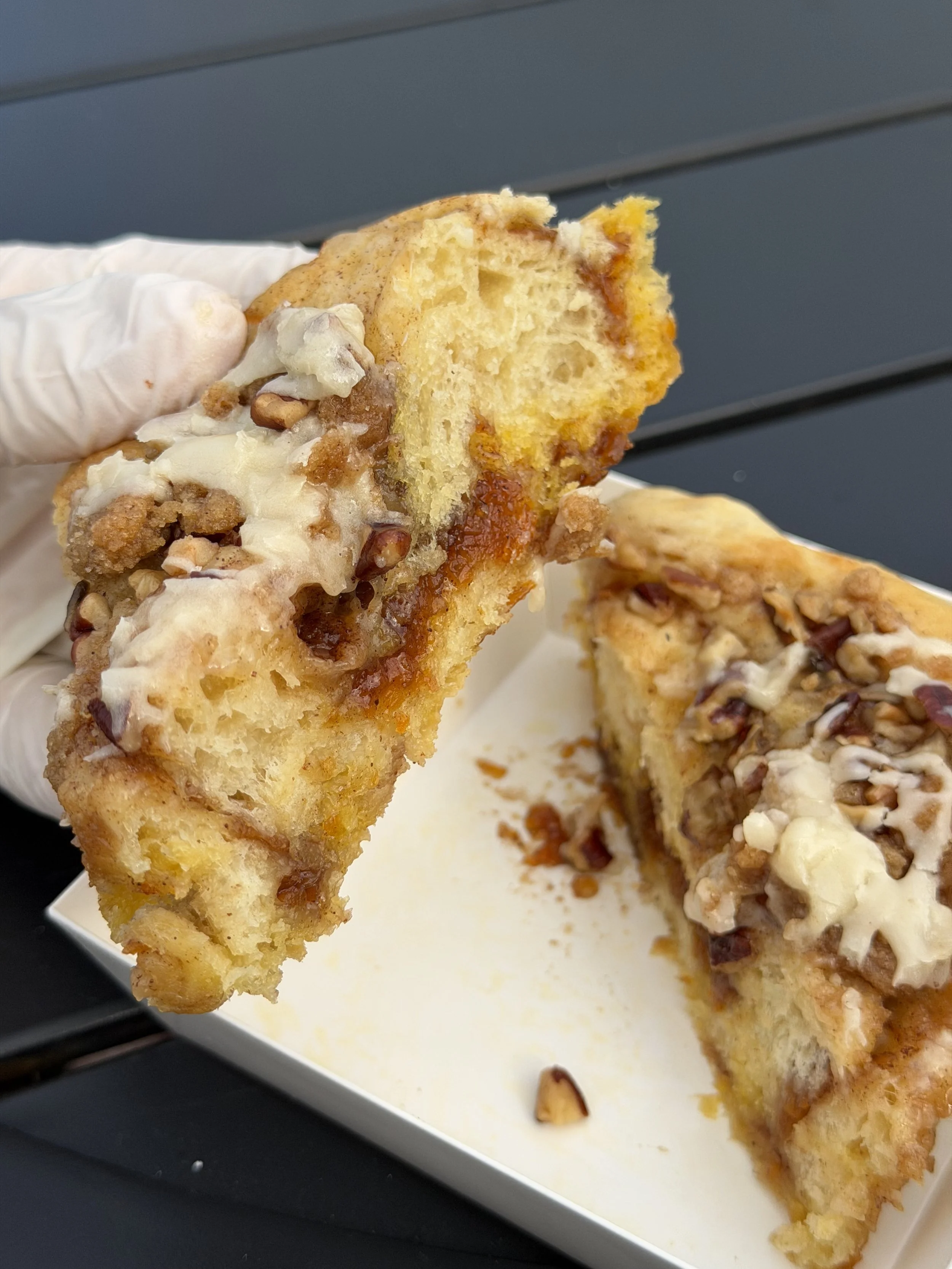 Carrot cake cinnamon roll from Salty Blonde Bakery with icing and pecan topping