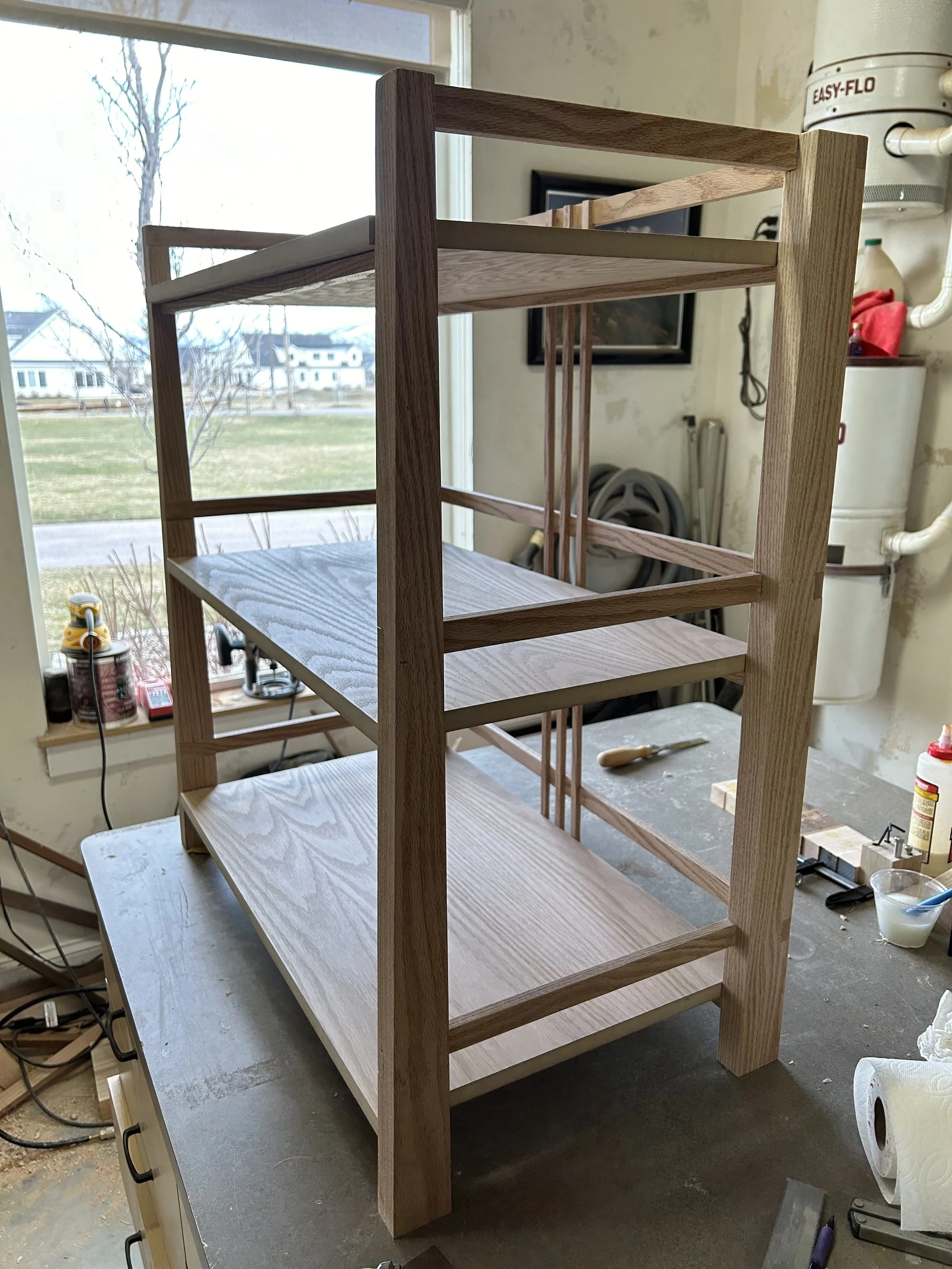 Custom mid-century modern wall shelf handcrafted from rift-sawn white oak in a Midway, Utah woodshop, featuring traditional joinery and a durable, hand-rubbed natural finish