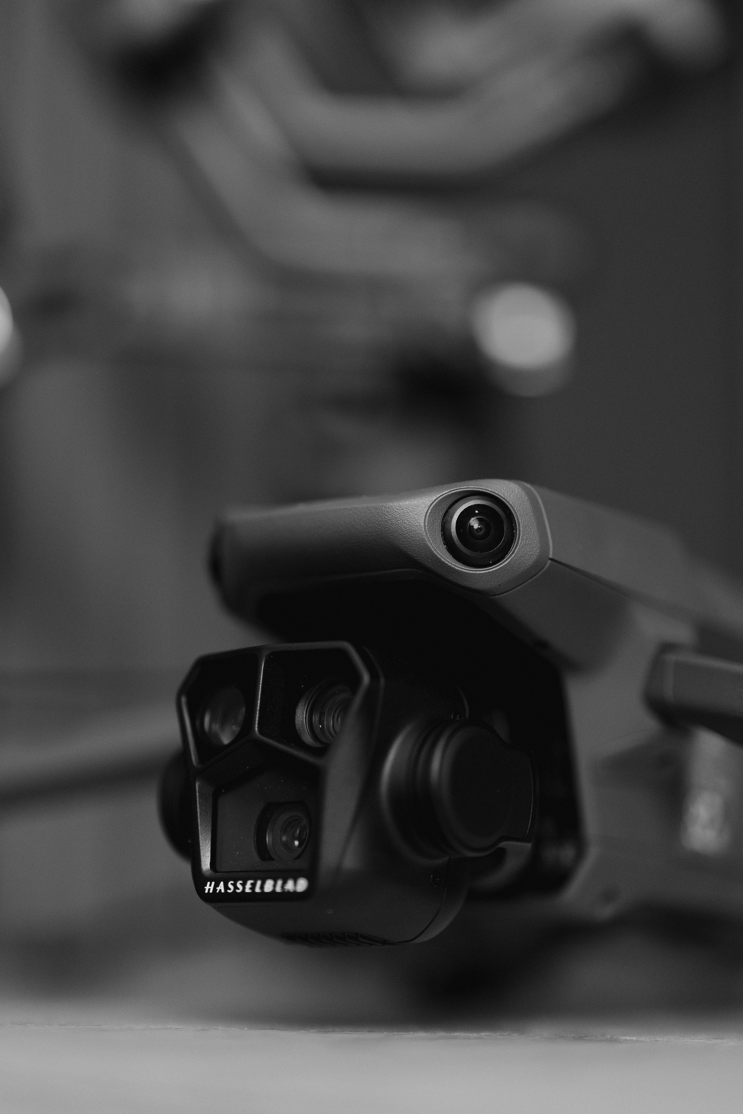 Black and white close-up of a drone with a Hasselblad camera attached, resting on a flat surface.