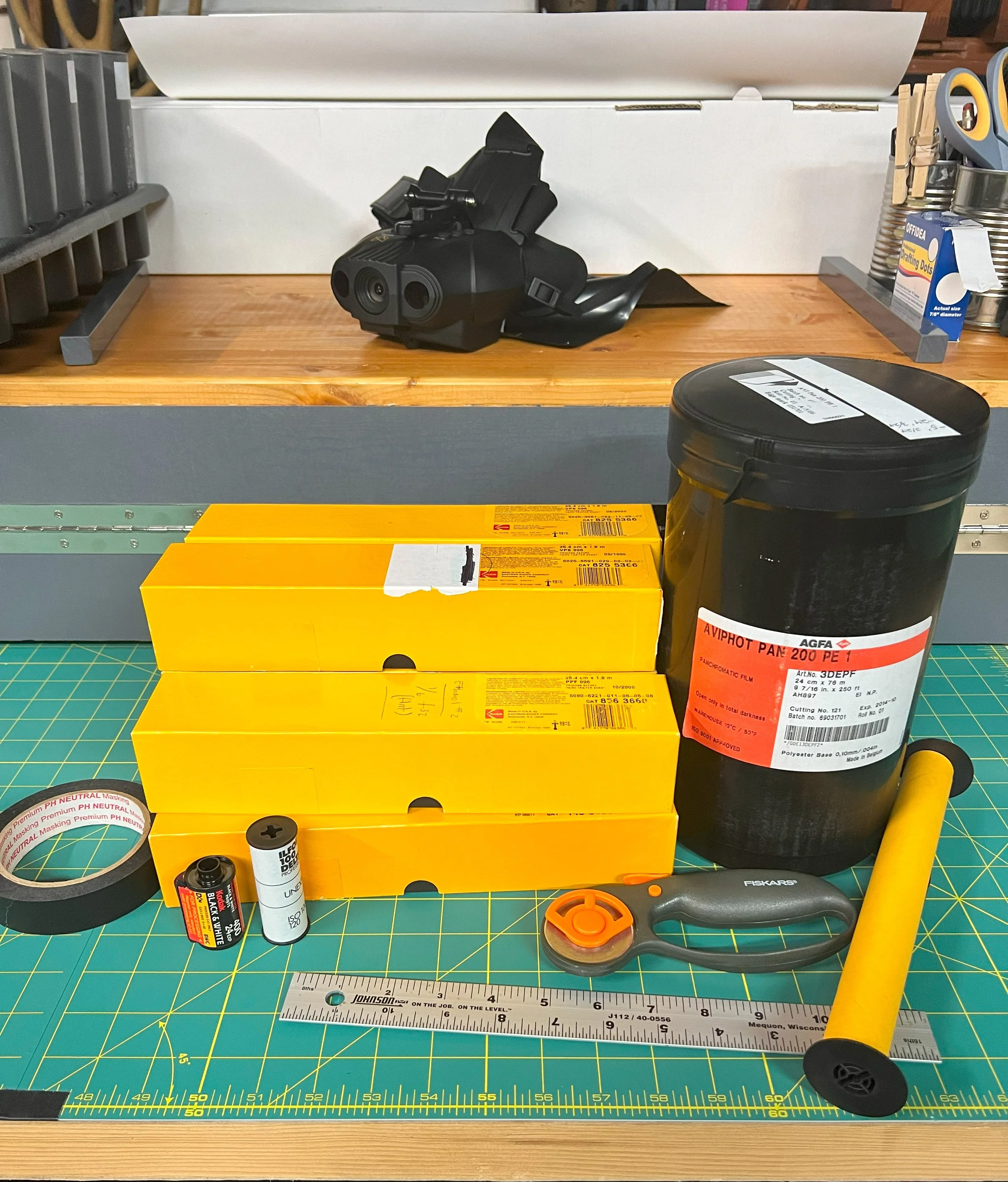 Spools of film, tape, a rotary cutter, and ruler