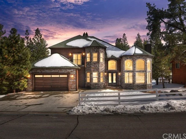 Custom 4,000 sq ft mountain home built by National Construction in Big Bear, with stone-and-timber exterior at dusk