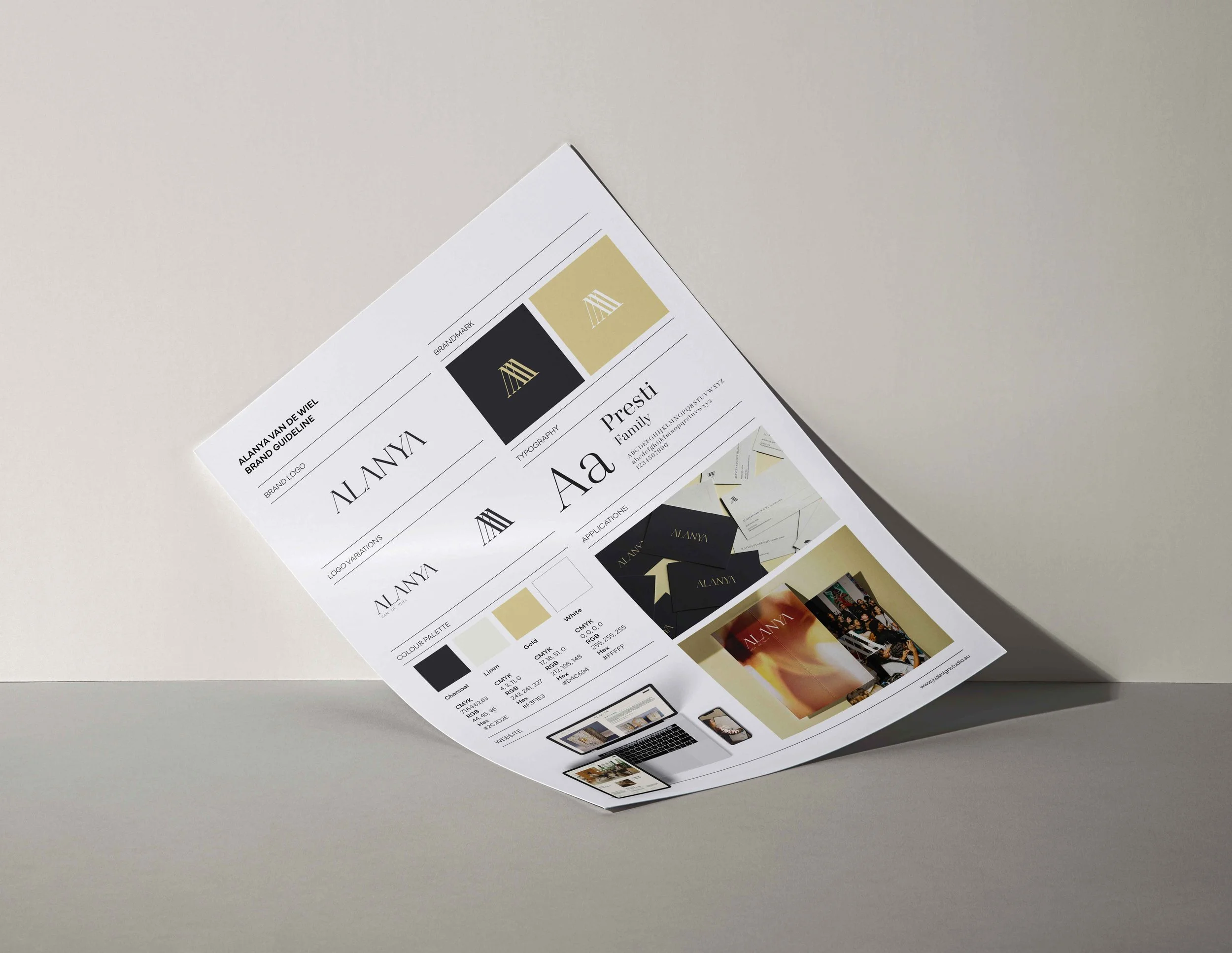 Printed branding guideline sheet with color palette, logo variations, typography, and application examples on white paper, placed on a light gray surface.