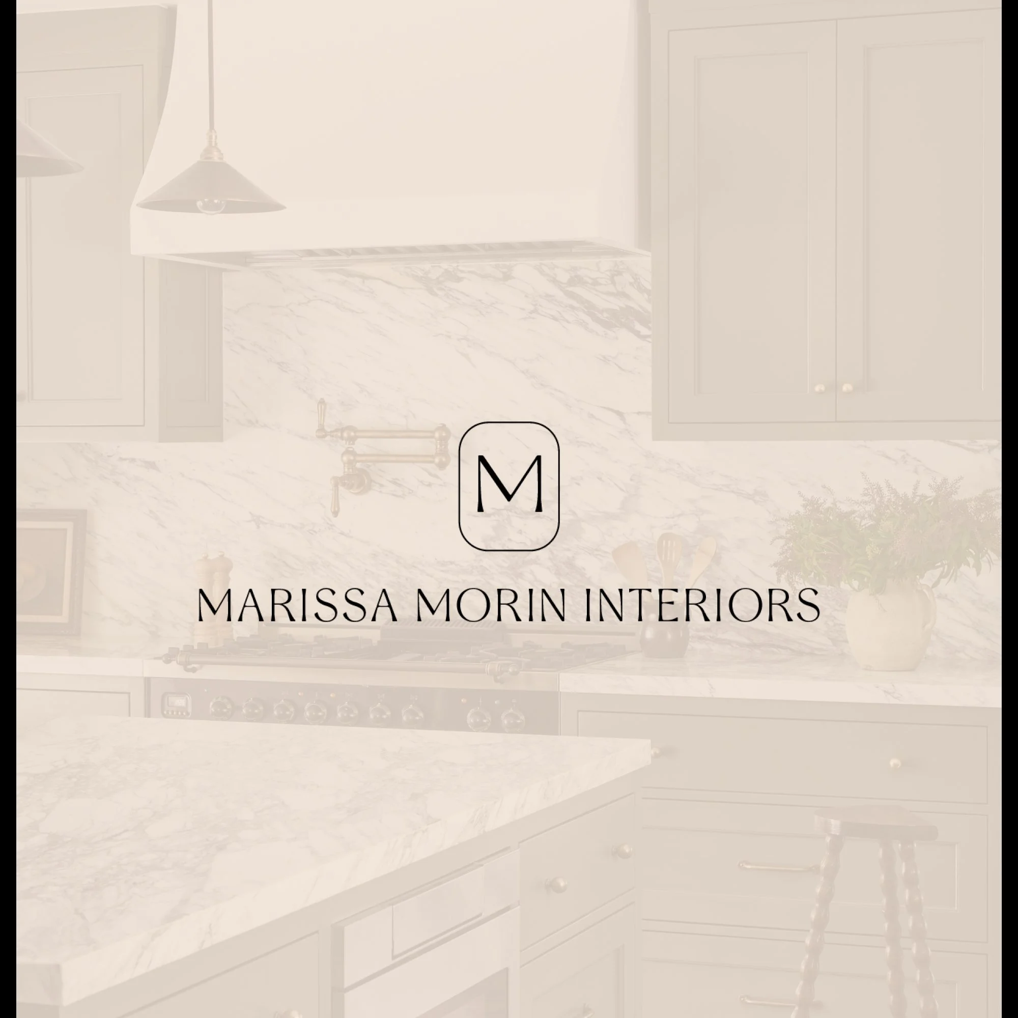 A modern kitchen with white marble countertops and backsplash, dark cabinetry, and pendant lighting. There are potted plants and kitchen utensils on the counter.