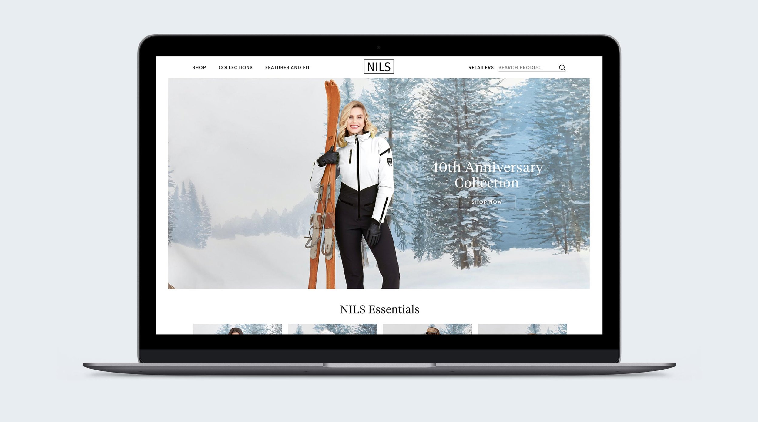 Laptop displaying a winter clothing website, featuring a woman in a white and black jacket holding skis in a snowy forest landscape.