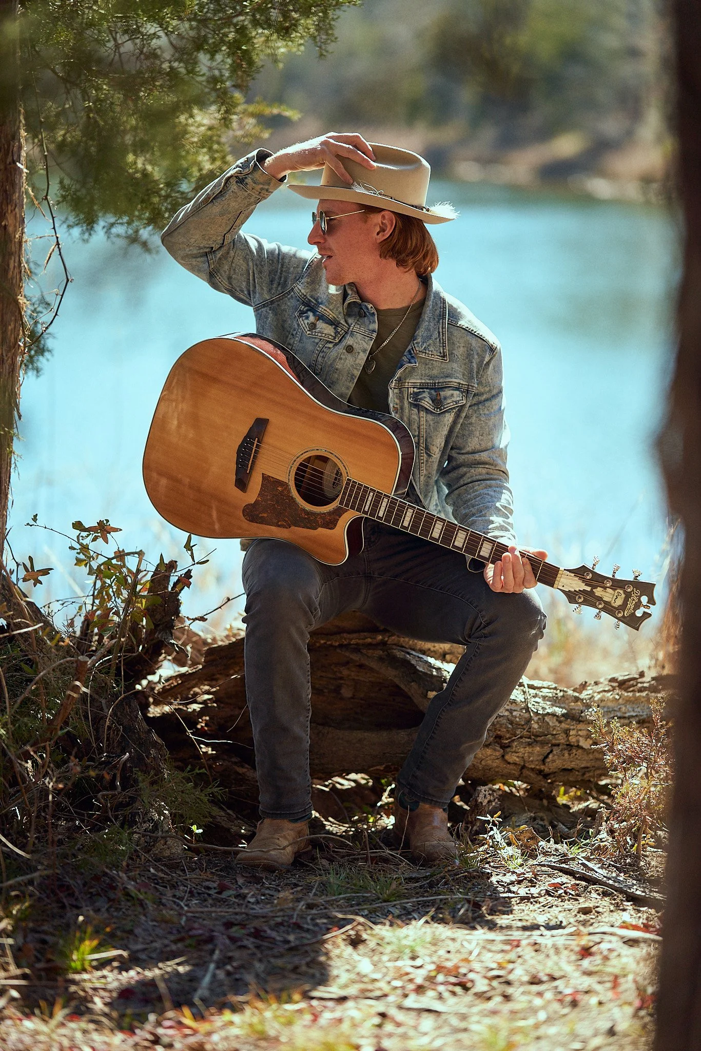 country artist sitting casually by water with guitar .jpg