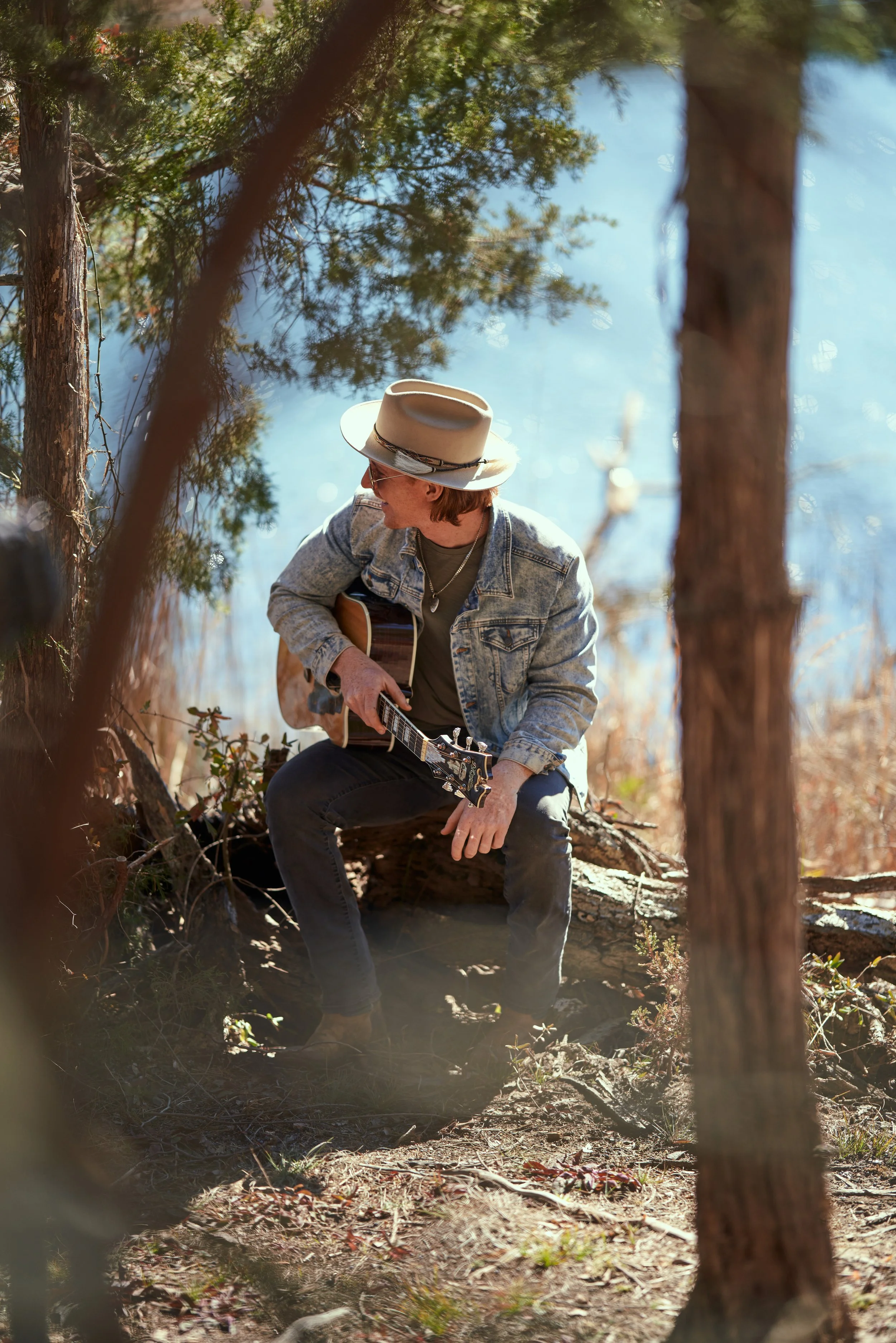 country artist playing guitar by water.jpg