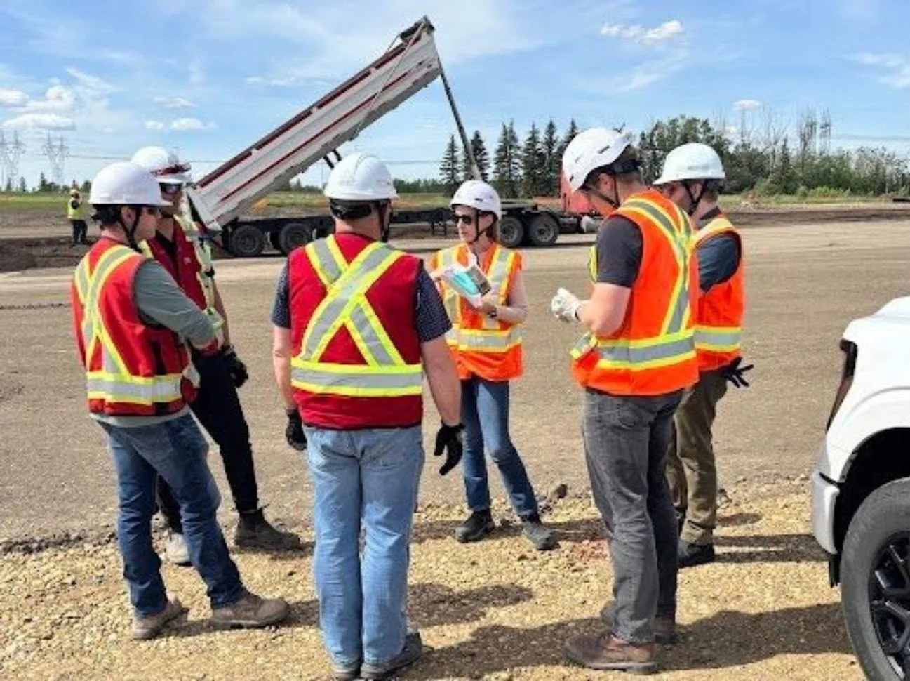 Jennifer Villeneuve, centre. holding event planning documents, leads a question and answer session with front-line workers in the days leading up to the media event.