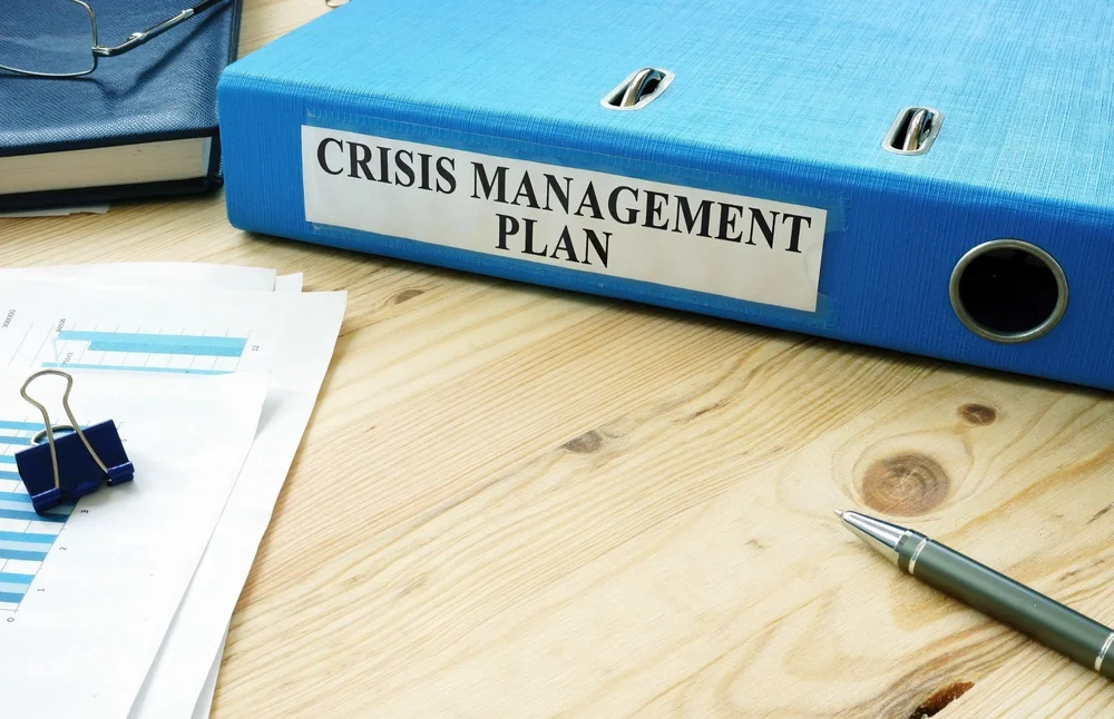 Crisis management plan binder on a desk