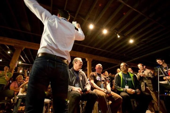 An organizer speaking to participants seated at the event