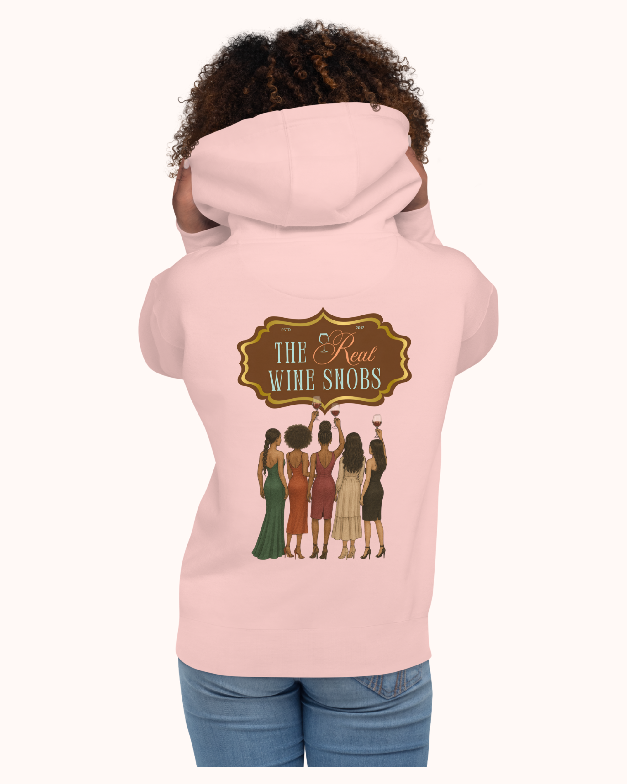 The Real Wine Snobs Snob Hoodie features women raising wine glasses beneath the brand crest. A fleece-lined hoodie designed for tastings, girls’ nights, and wine lovers with a little attitude.