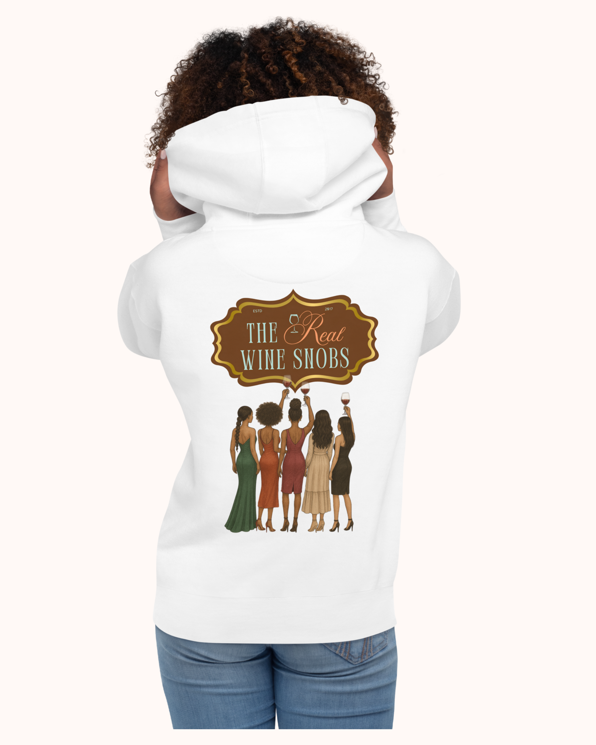 The Real Wine Snobs Snob Hoodie features women raising wine glasses beneath the brand crest. A fleece-lined hoodie designed for tastings, girls’ nights, and wine lovers with a little attitude.