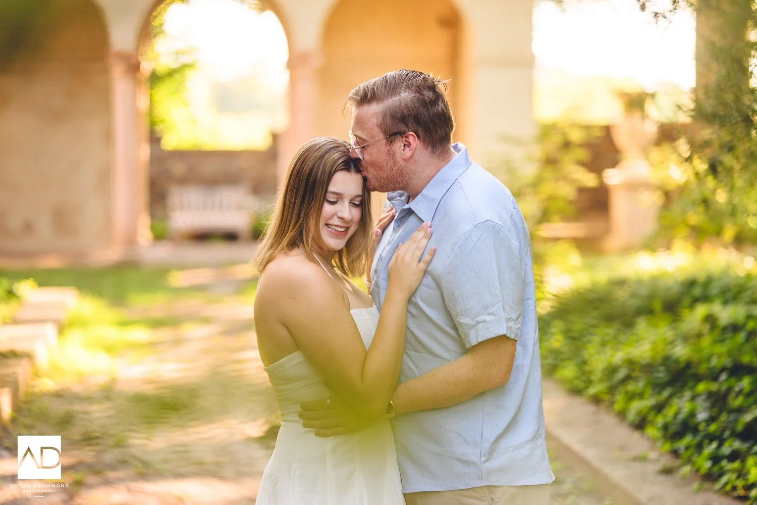 Anton Drummond captures an intimate forehead kiss beneath the Gibraltar loggia during a golden hour engagement session