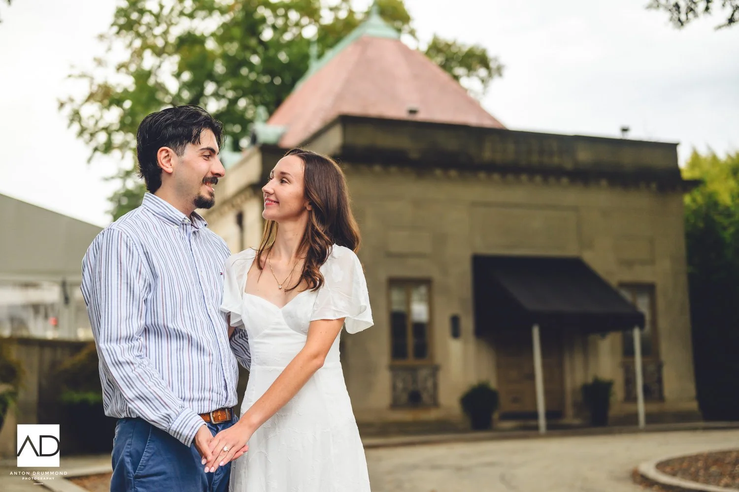 Emily and Joe holding hands and smiling at each other — Montgomery County wedding photographer — Curtis Hall blurred behind