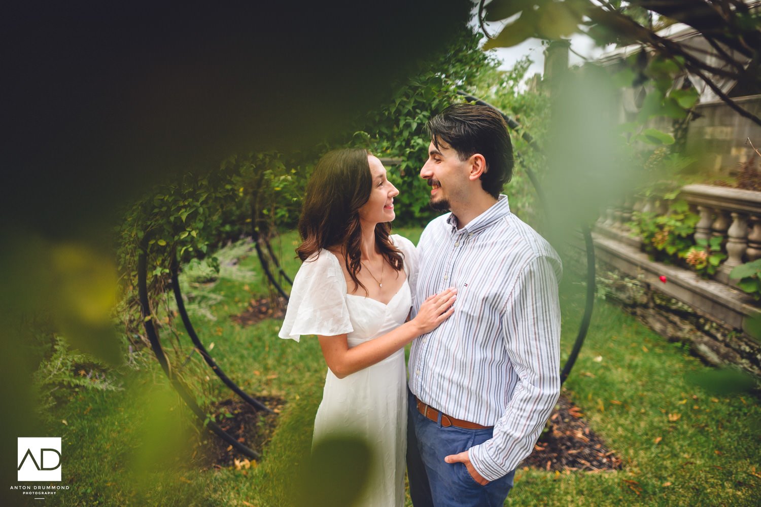 Curtis Arboretum engagement session — Emily's hand on Joe's chest, both smiling inside the vine arbors
