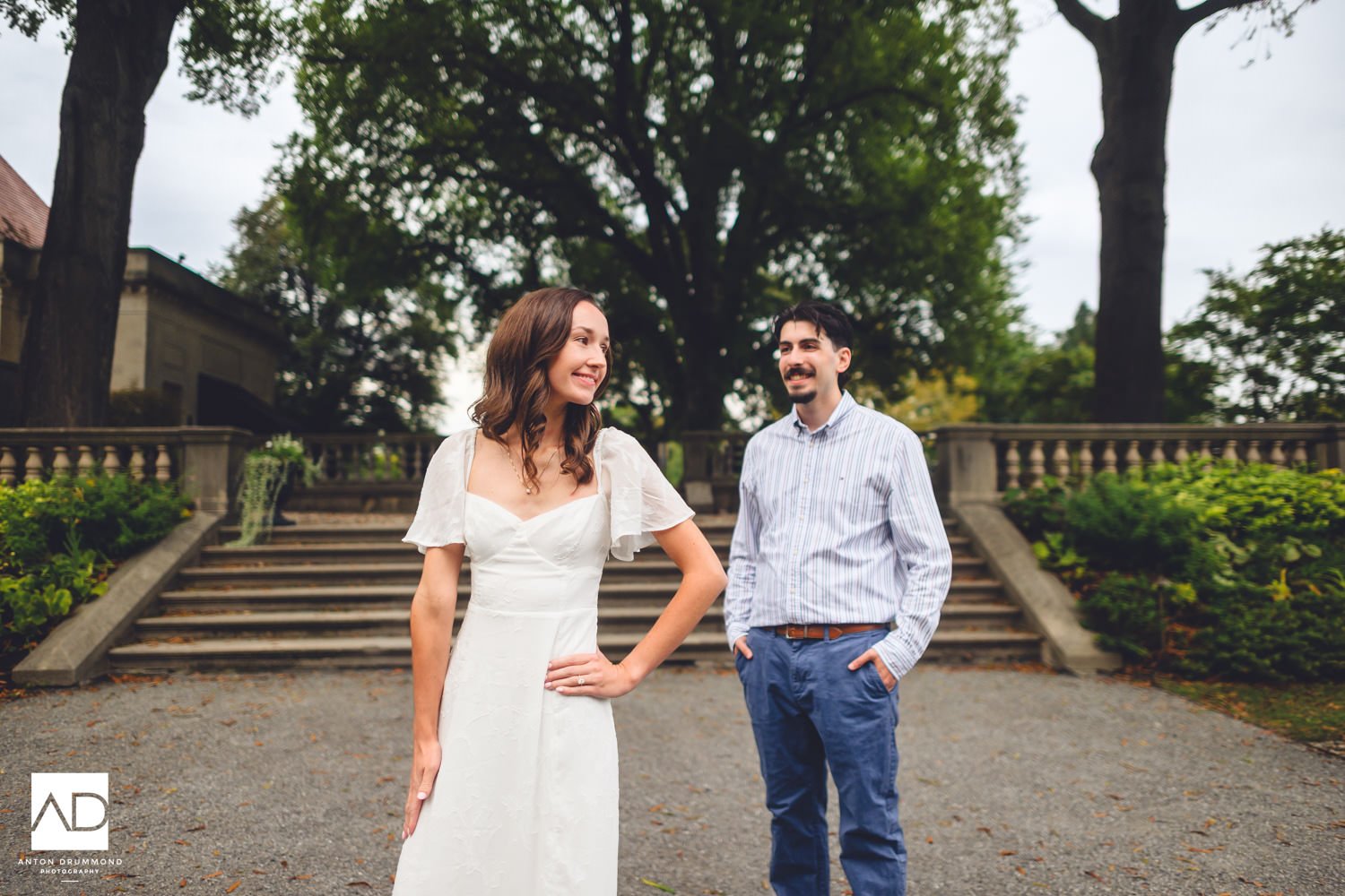 Emily with hand on hip, engagement ring on full display — Wyncote PA engagement photographer — Joe smiling behind her