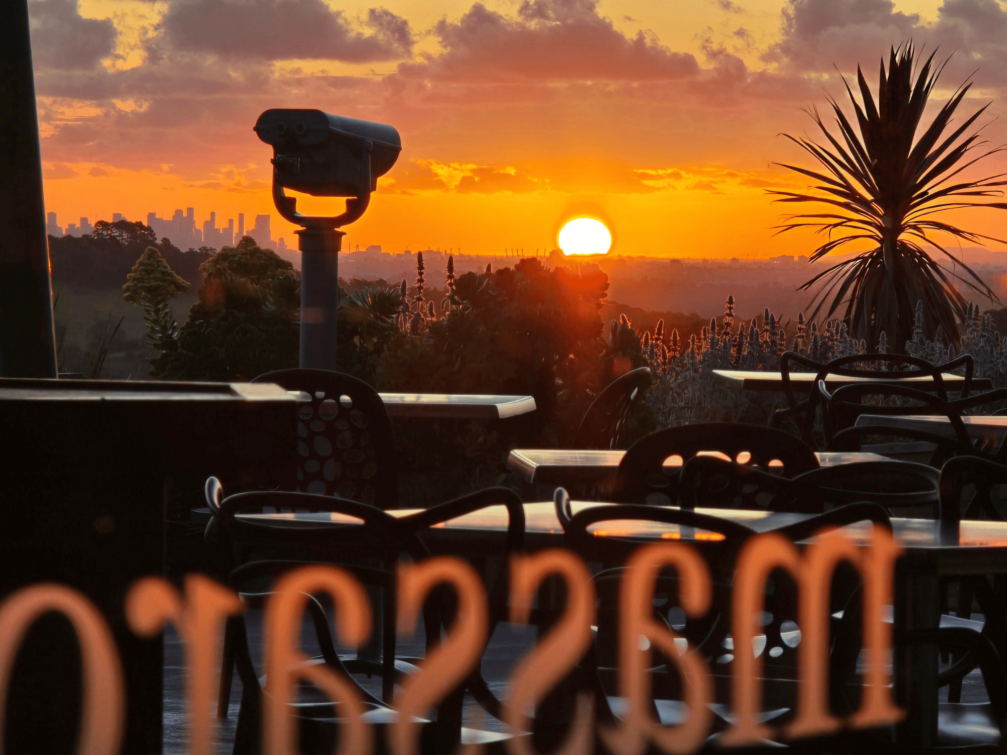 Dramatic golden sunset over Melbourne city skyline viewed from a hilltop lookout in the Yarra Valley