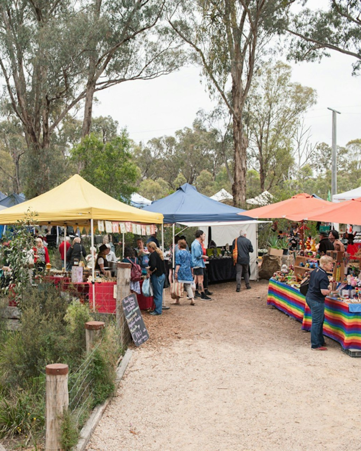 Colourful outdoor market stalls among gum trees near the Yarra Valley, a short drive from Melbourne