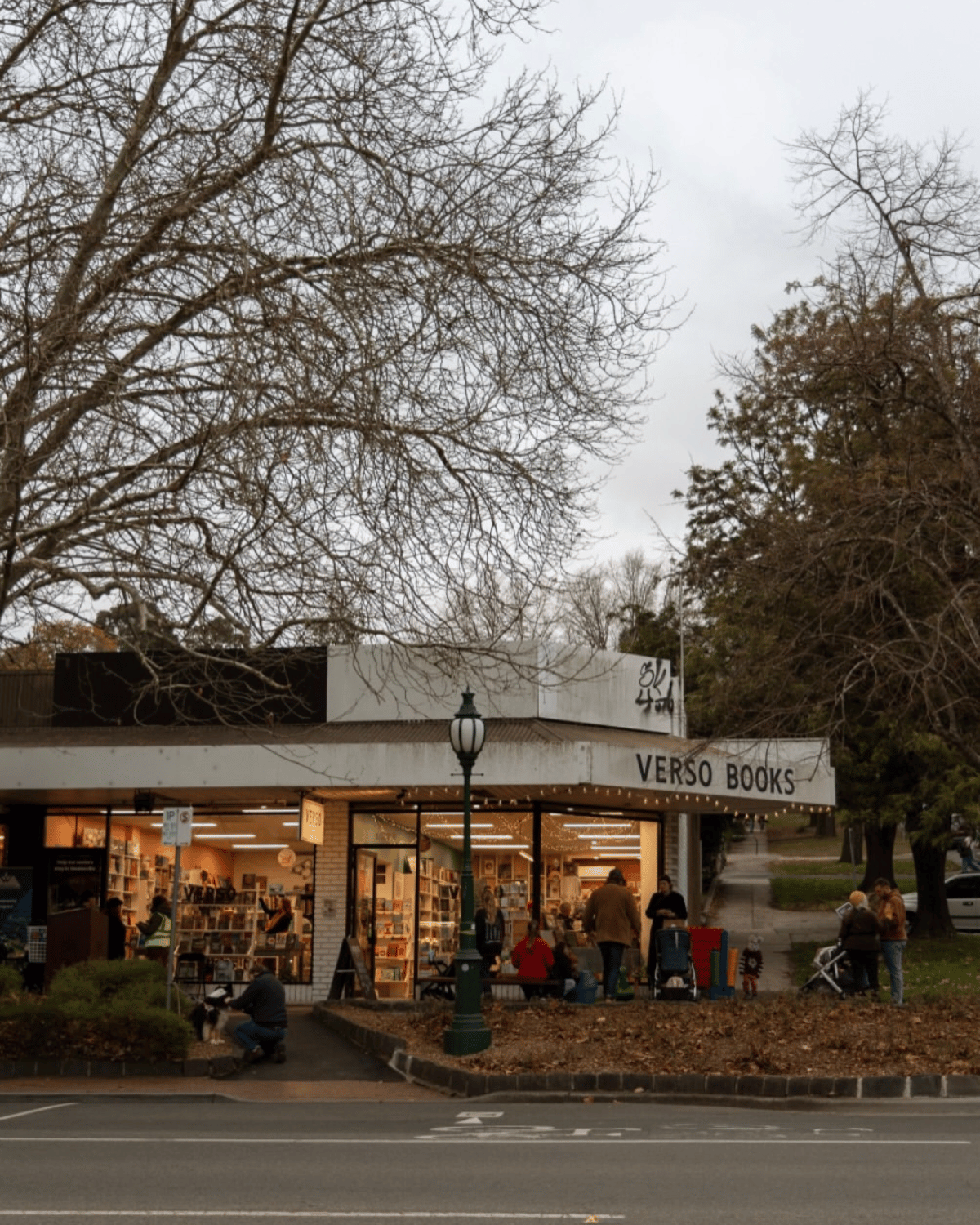 Verso Books independent bookshop in Healesville lit up at dusk with people browsing outside, Yarra Valley Victoria