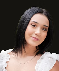 A young woman with shoulder-length dark hair, wearing a white top, smiling slightly while looking at the camera against a black background.