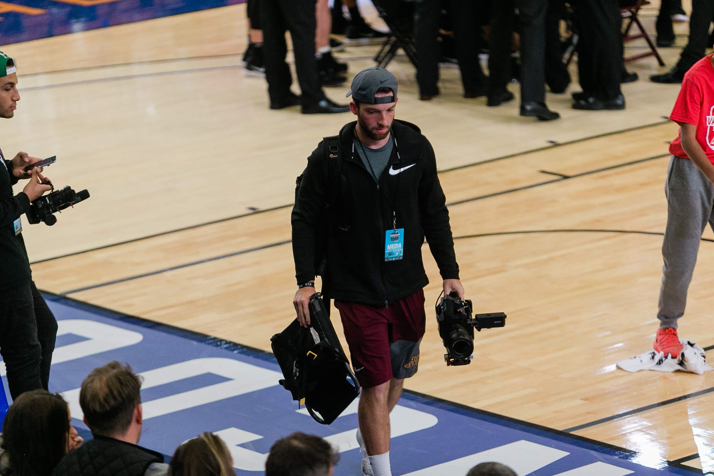 People with cameras on a basketball court