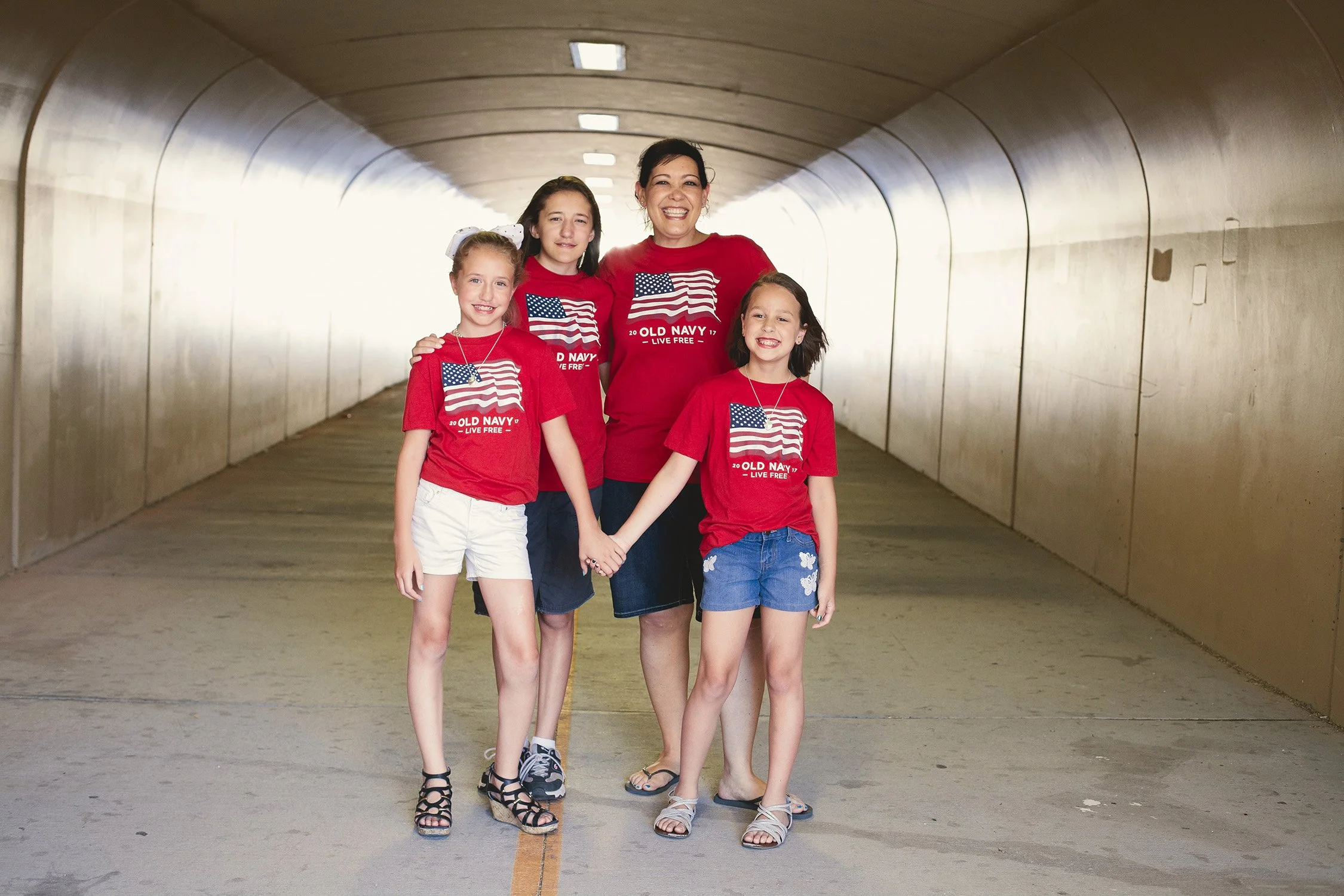 a family standing at the end of a tunnel smiling at the camera, an auntie and her nieces