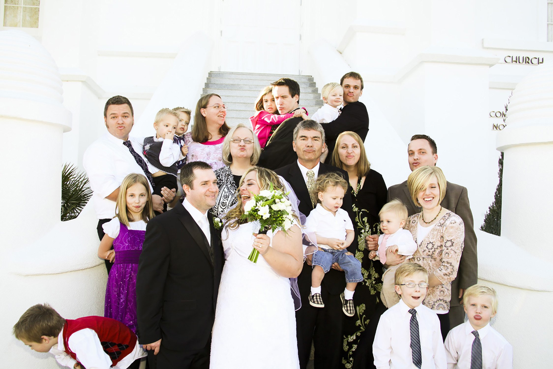 an extended family group photo with everyone being silly and chaotic