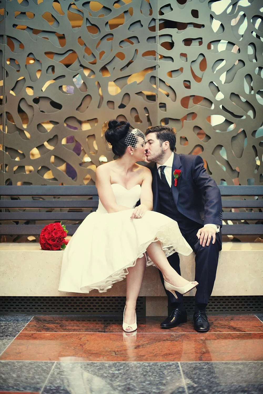a bride and groom sitting in the lobby at a hotel in Las Vegas, they are about to kiss