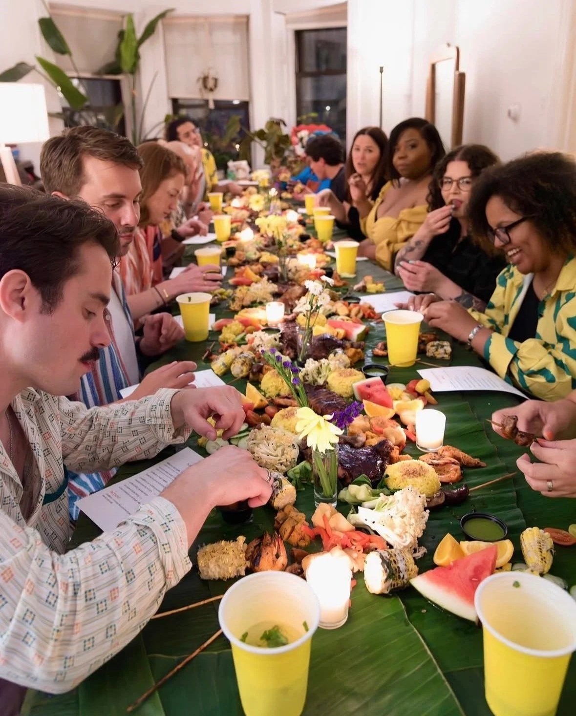 a group of people on a dinner table with a bounty of food