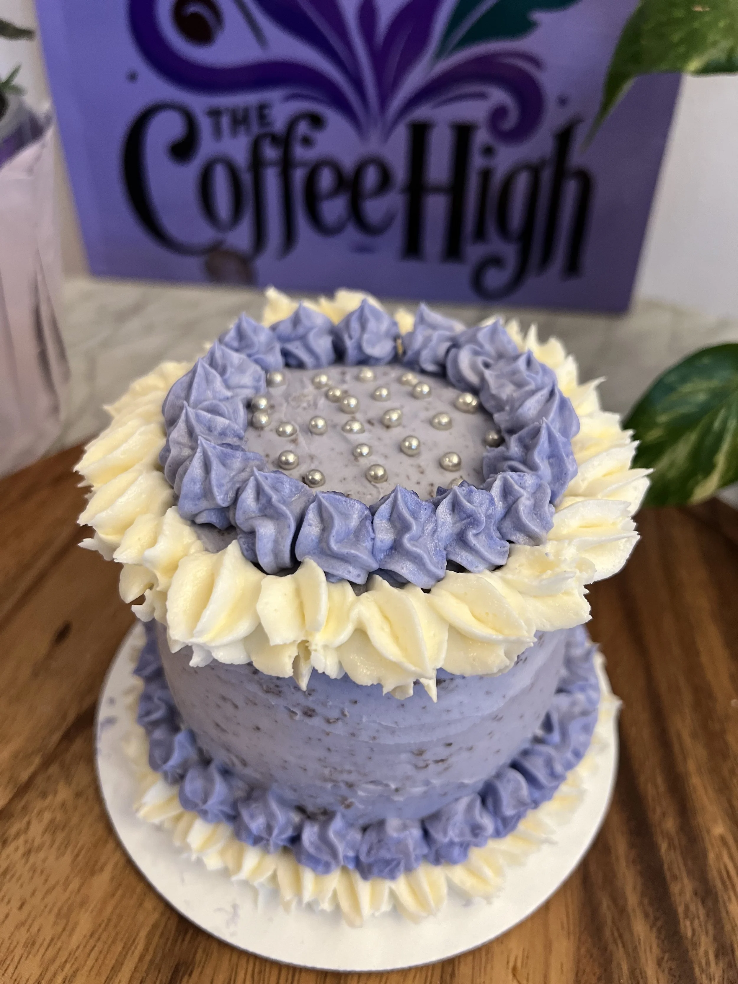 Purple and white frosting piped around the cake