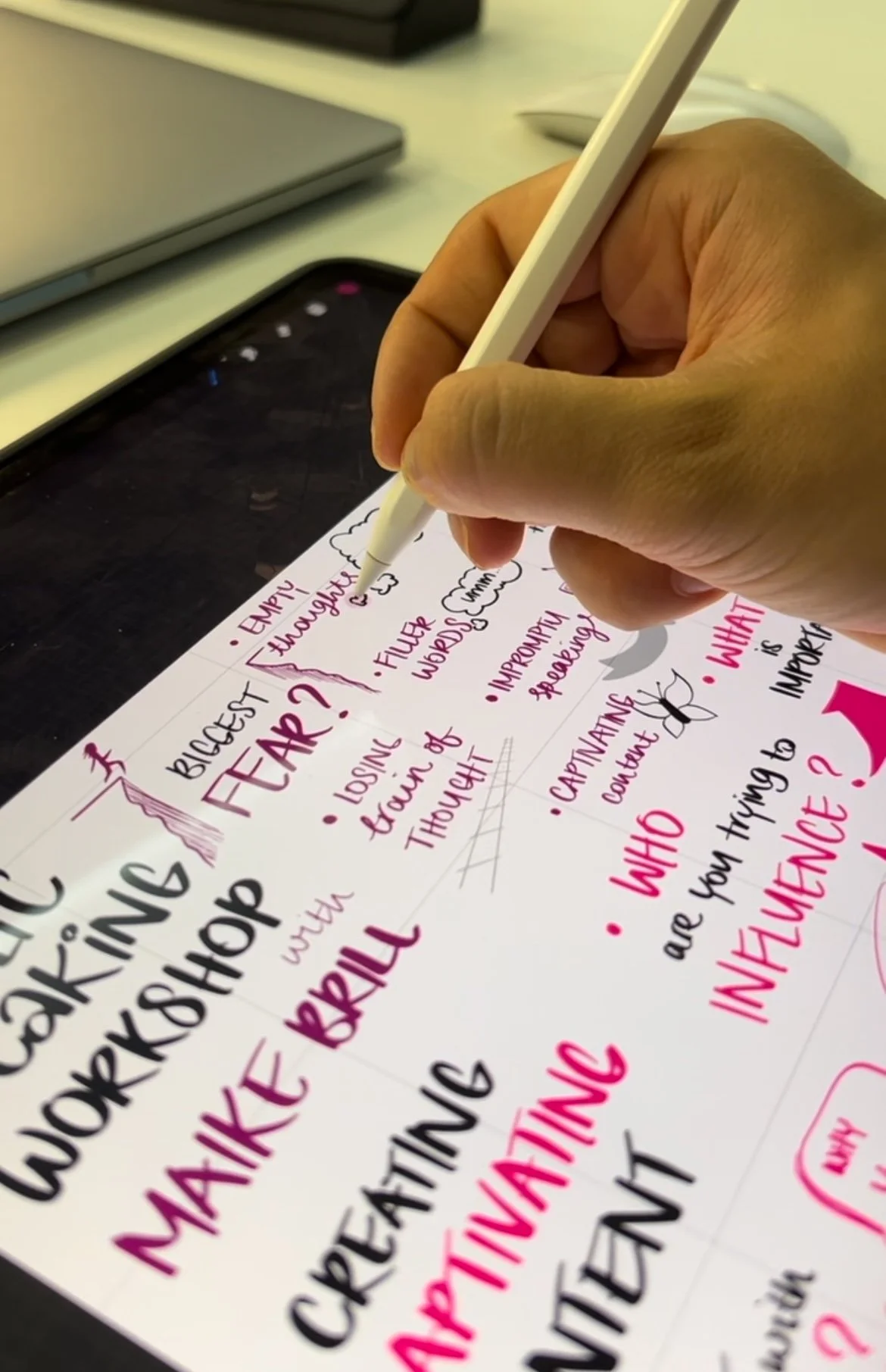 Person using a stylus on a tablet to illustrate infographics with handwritten words related to a public speaking workshop, including terms like 'biggest fear,' 'filler words,' and 'captivating content.'