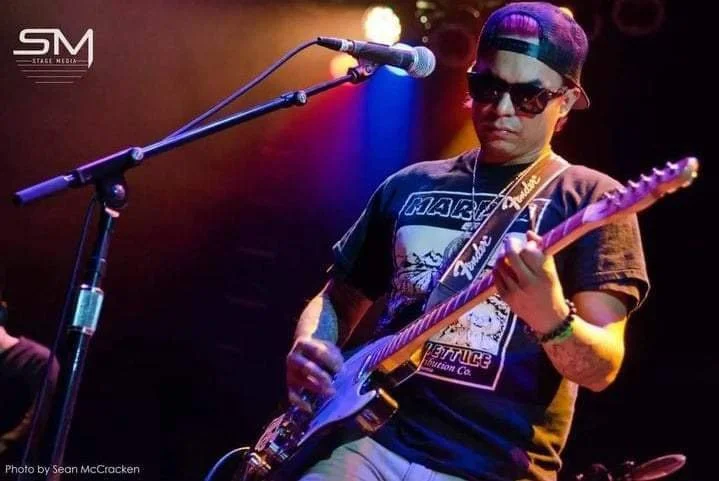 Closeup of Skunkdub playing guitar