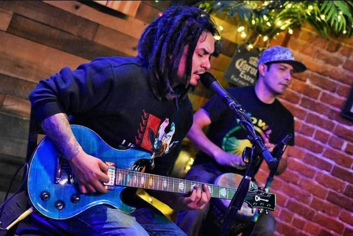 Photo os Skunkdub singing and playing guitar.