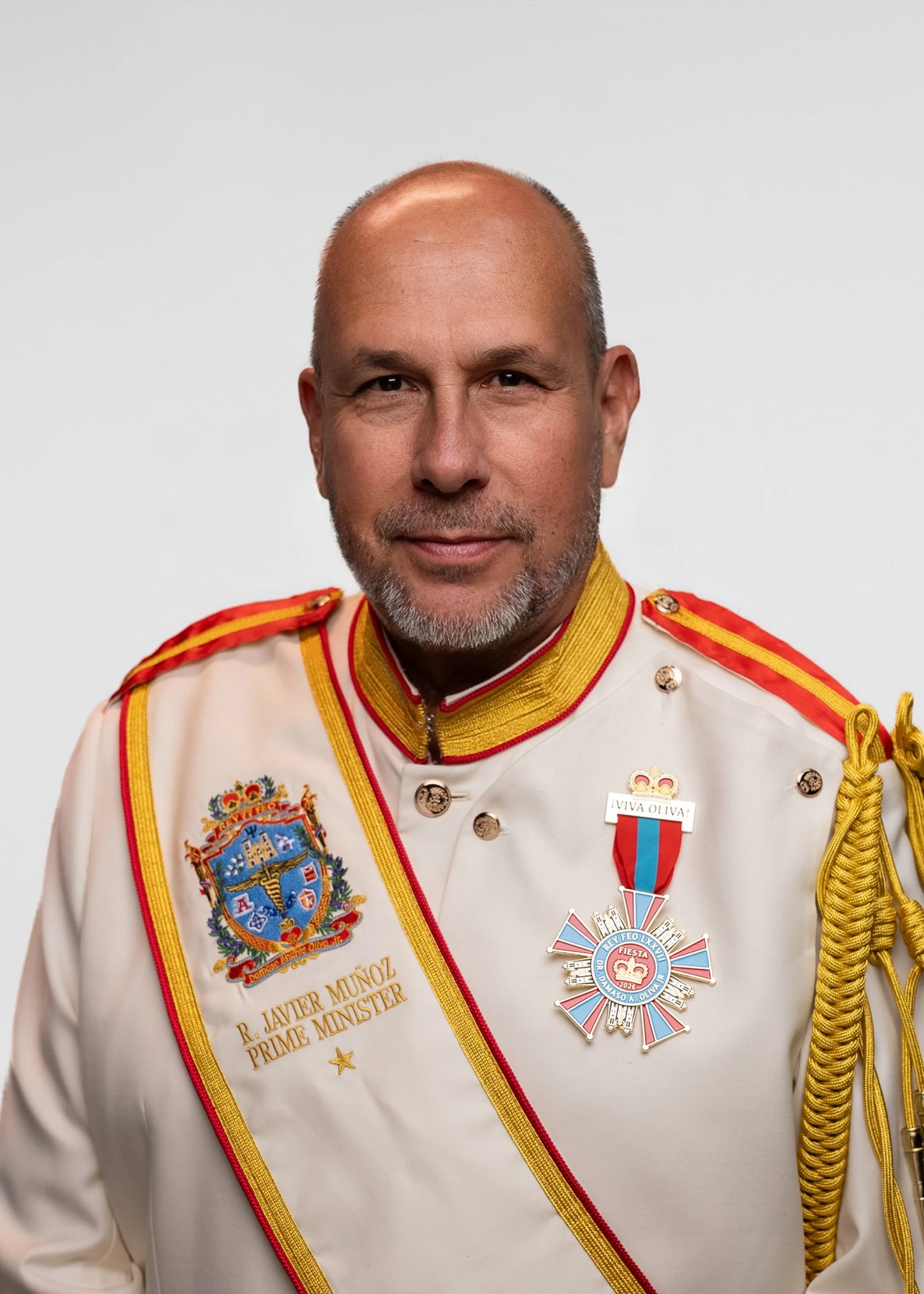 A smiling middle-aged man with a goatee, wearing a bright red button-up shirt, against a plain gray background.