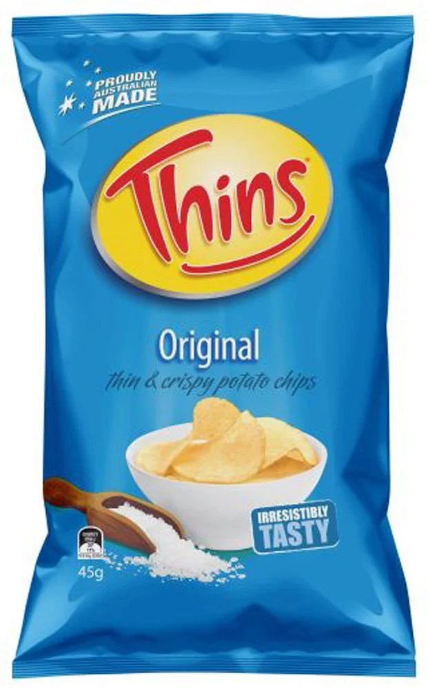 A blue bag of Thins Original thin and crispy potato chips with a bowl of chips and a wooden scoop on the front.