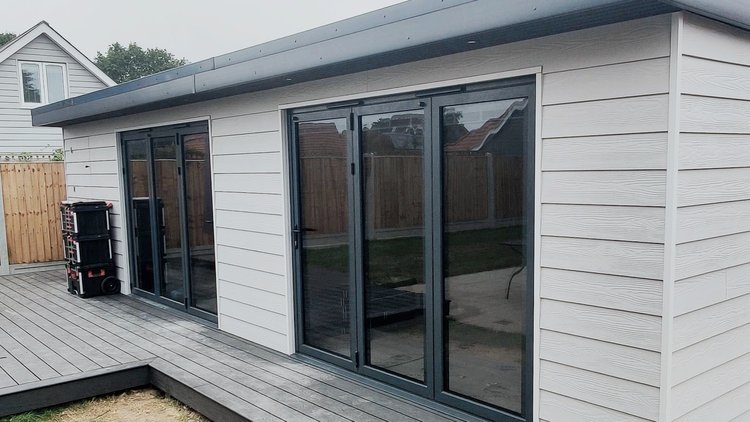 Garden room with Korniche aluminium sliding doors and grey composite decking